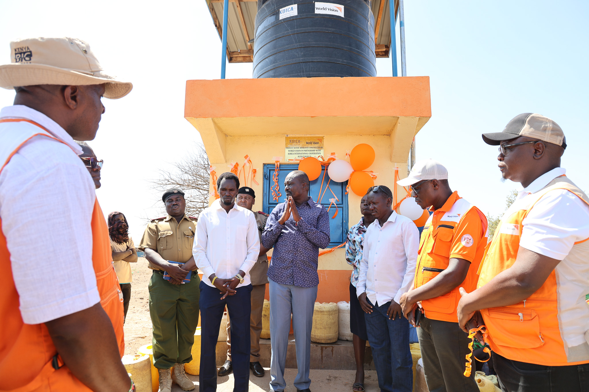 From Left to Right: World Vision Kenya Cluster Manager for Turkana & West Pokot, Tom Masinde (left), Anthony Oyugi, K-Dream Project Manager (front right), and William Omole, Ag. Disaster Management Director, (second right) join the CEC of Water Services, Turkana County, and local leaders for the official handover of the Eskiriat water kiosk with an elevated storage tank to the community. © World Vision Kenya/ Jared Ontobo