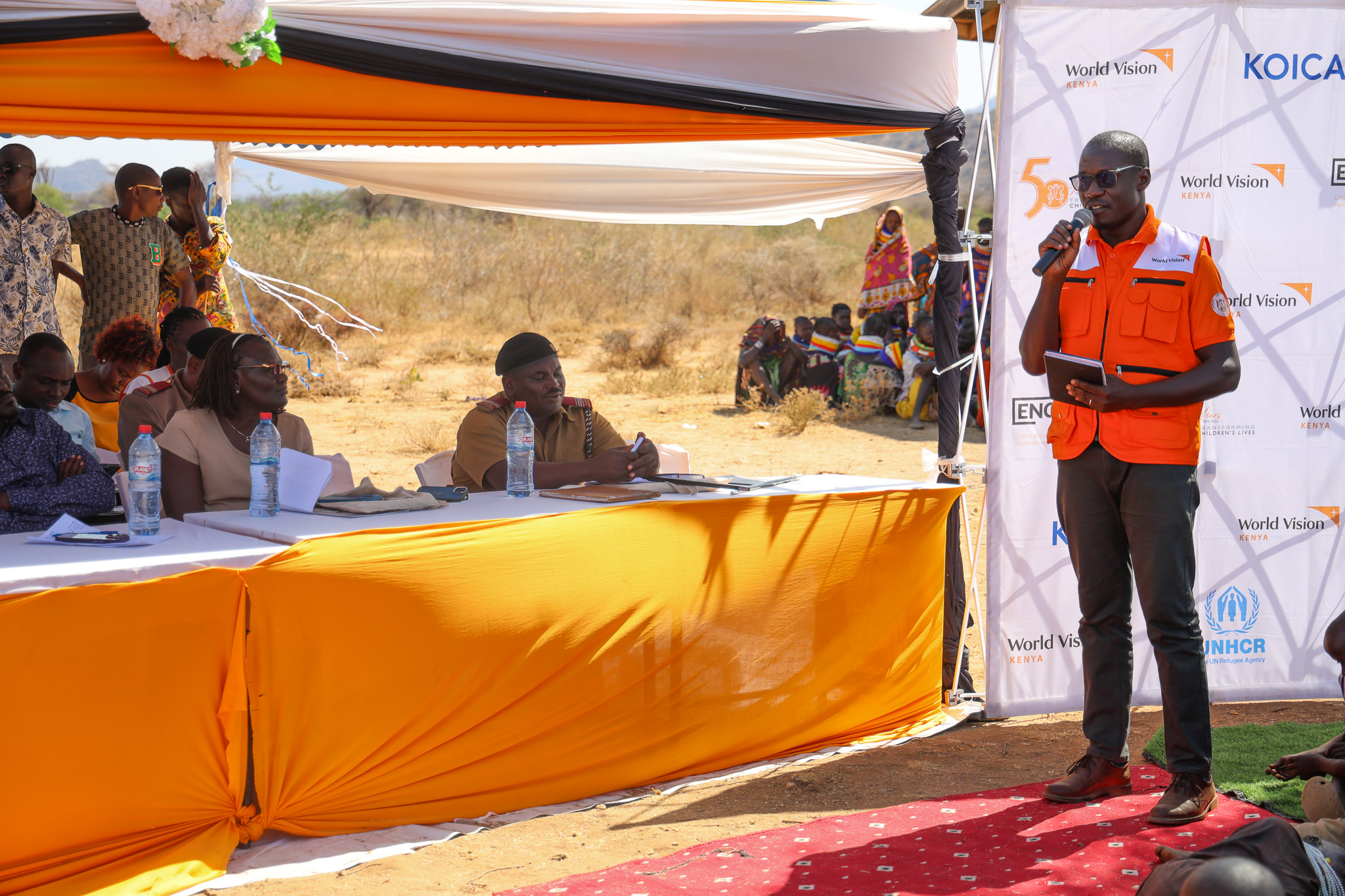 William Omole, Ag. Disaster Management Director, World Vision Kenya, addresses the gathering at Nalapatui village during the handover of the K-DREAM project to the community. © World Vision Kenya/ Jared Ontobo
