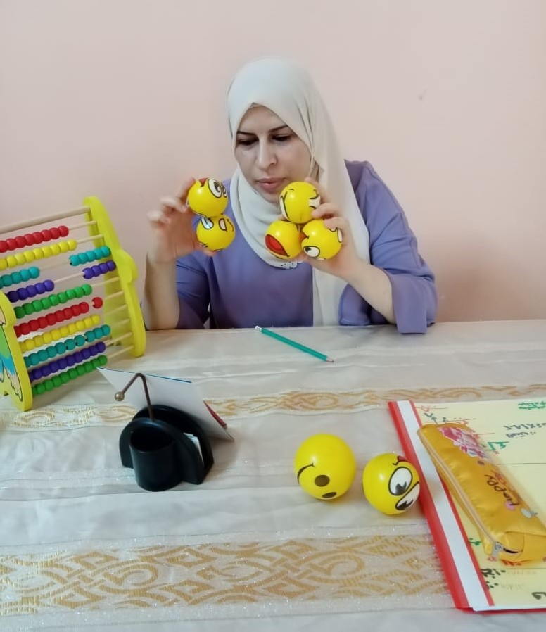 Safaa is using small balls to explain the addition lesson properly.  The teacher is using variable teaching and learning materials to attract the students’ attention.