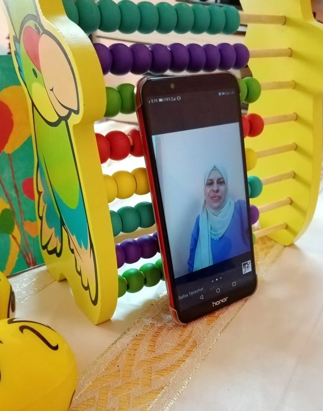 Safaa is recording herself explaining today’s lesson to the students. The teacher is using any type of equipment she has at home to ensure the best video experience for children during the classes.