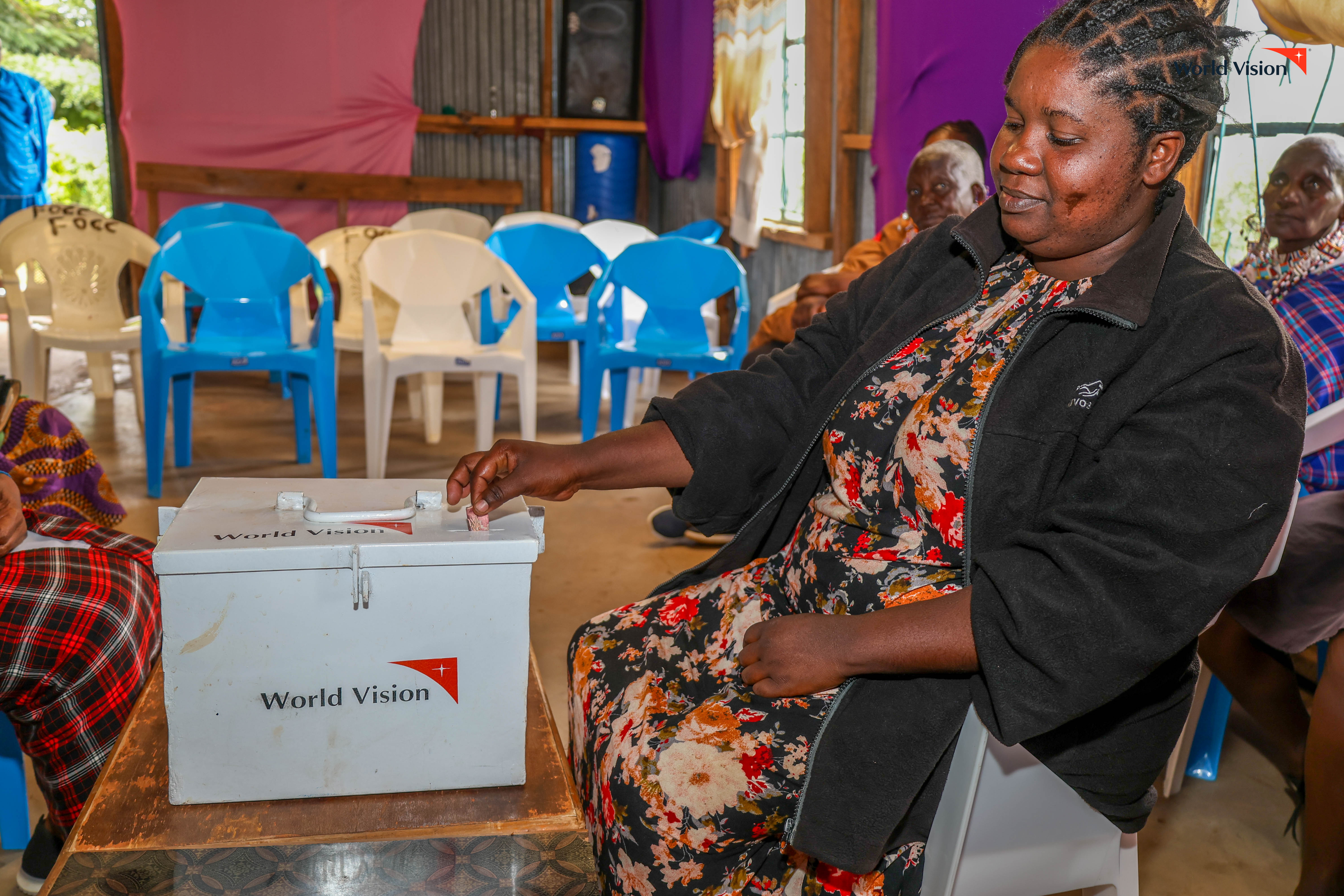 Felister deposits her savings in the group’s savings box during one of their weekly meetings at Maili Tisa in Oldonyo Orok. ©World Vision Photo/Mirriam kioko