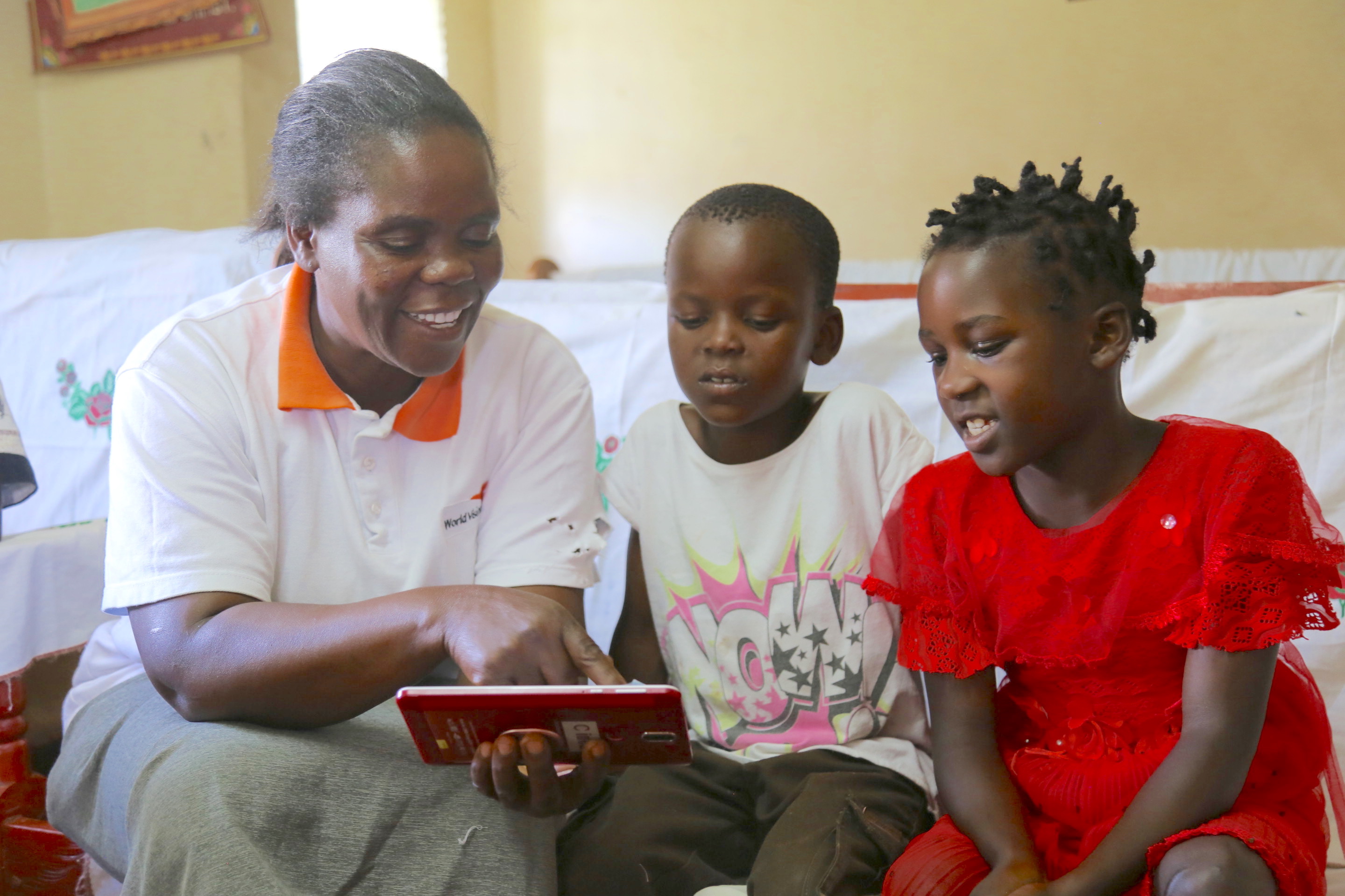 Anne Rengo helping her two children; 9 year old Minha Chelimo (Right)  and 8 year old Lavingtone Rengo (left) to study at her home in Lwandeti. The mother got the knowledge from Women for The web training facilitated by World Vision.