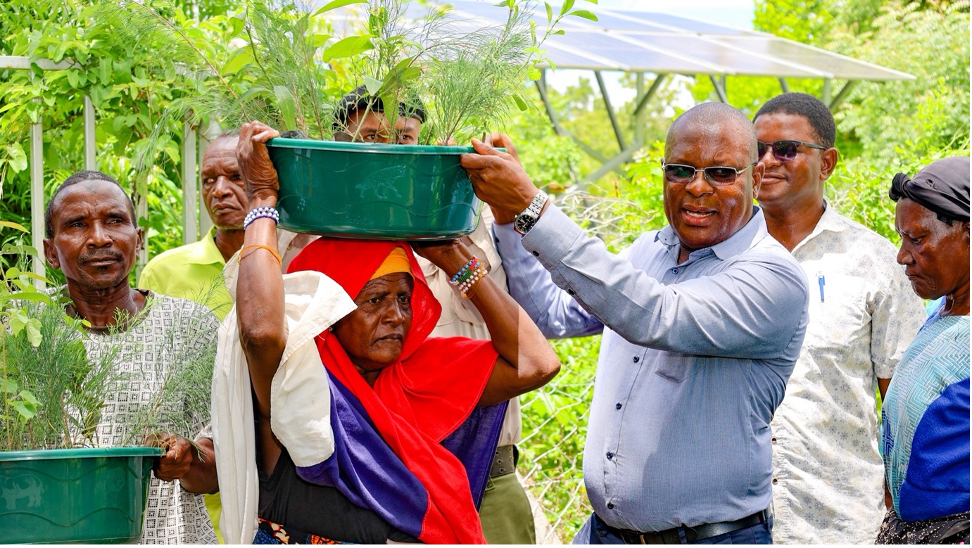 Hon. Roman Shera, Kwale County CECM for Agriculture, Livestock and Fisheries, hands over tree seedlings to farmers during a tree distribution exercise in Vanga Ward.