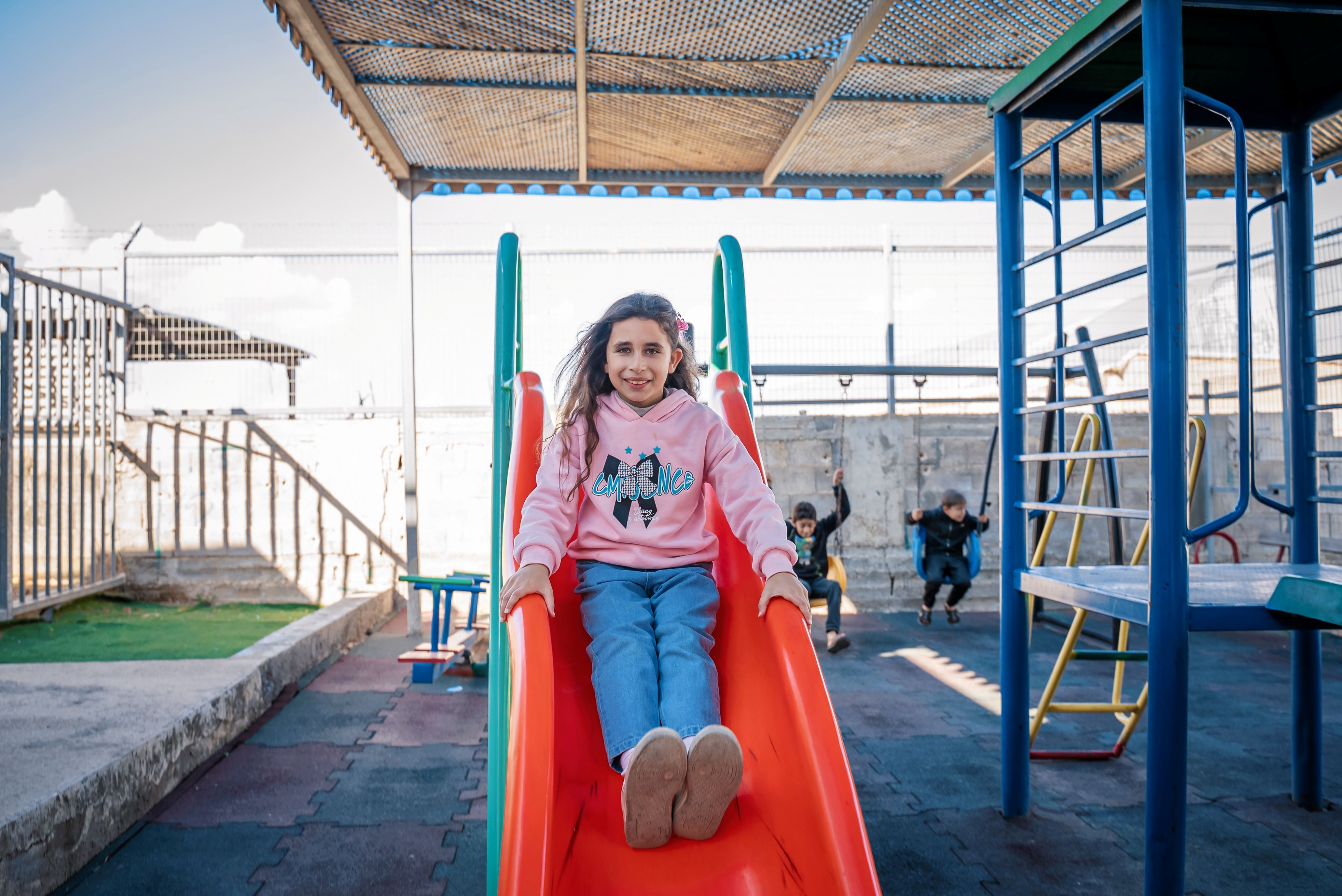 A child plays in a newly created safe play area in the north of the West Bank