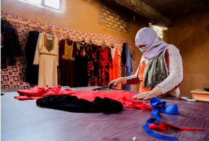 Fatima in her shop while tailoring