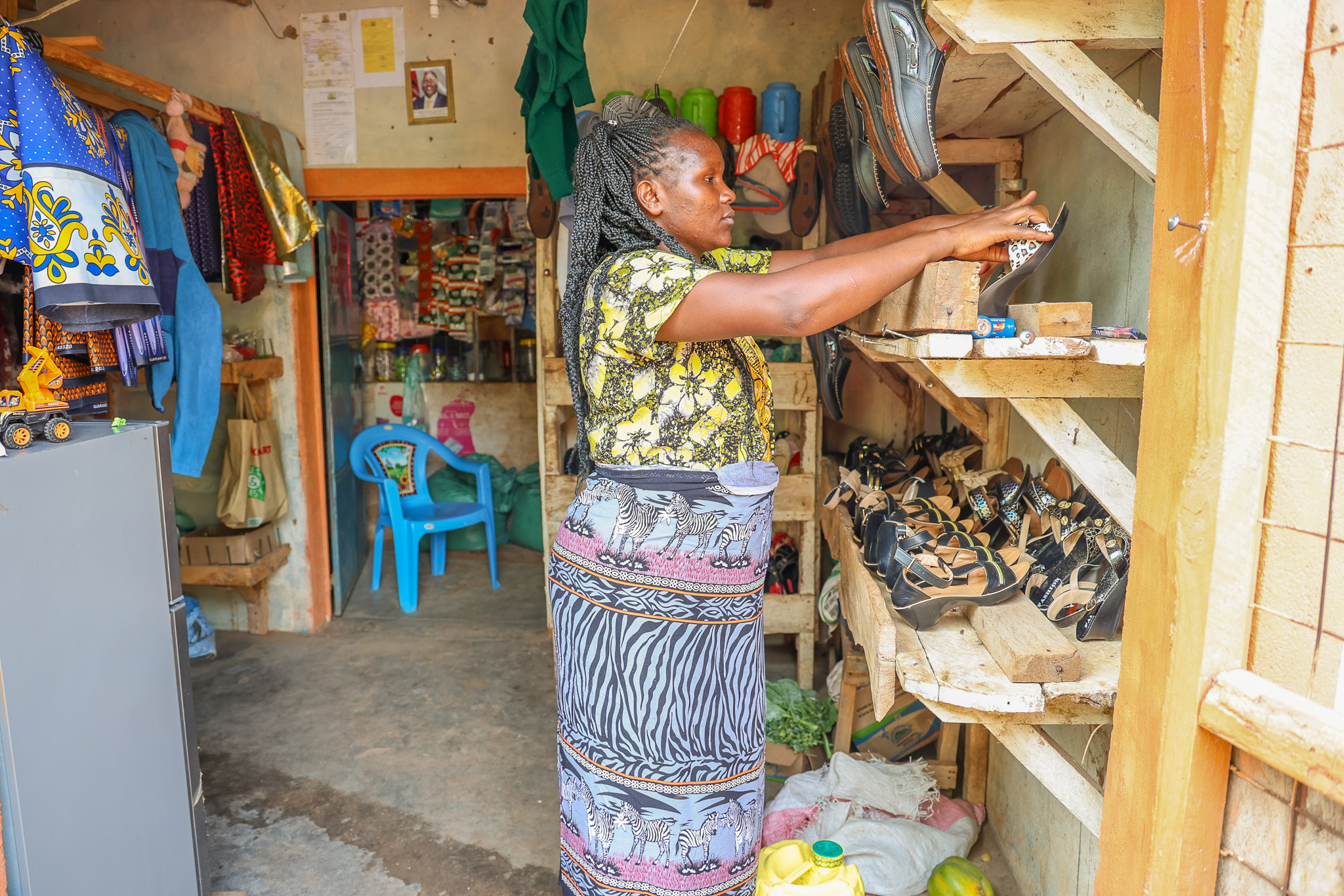 Cecilia Kiminza, a member of Wendo wa Kiange VSLA in Kiange, Mutomo, Kitui South, has expanded her shop using savings and loans from the group. What started as a small outlet now sells a variety of items, including shoes and clothes. © World Vision Kenya/ Jared Ontobo