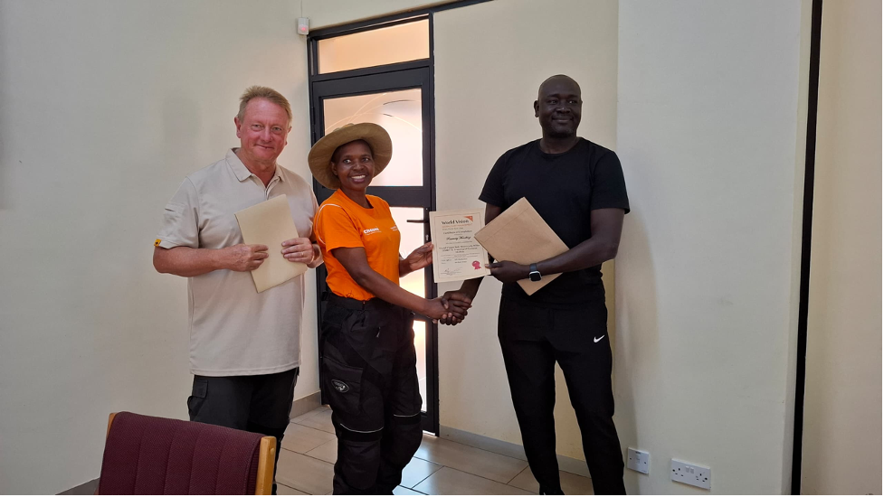 Rosemary receives her certificate from the two trainers, Neil (left) and Benjamin (right)
