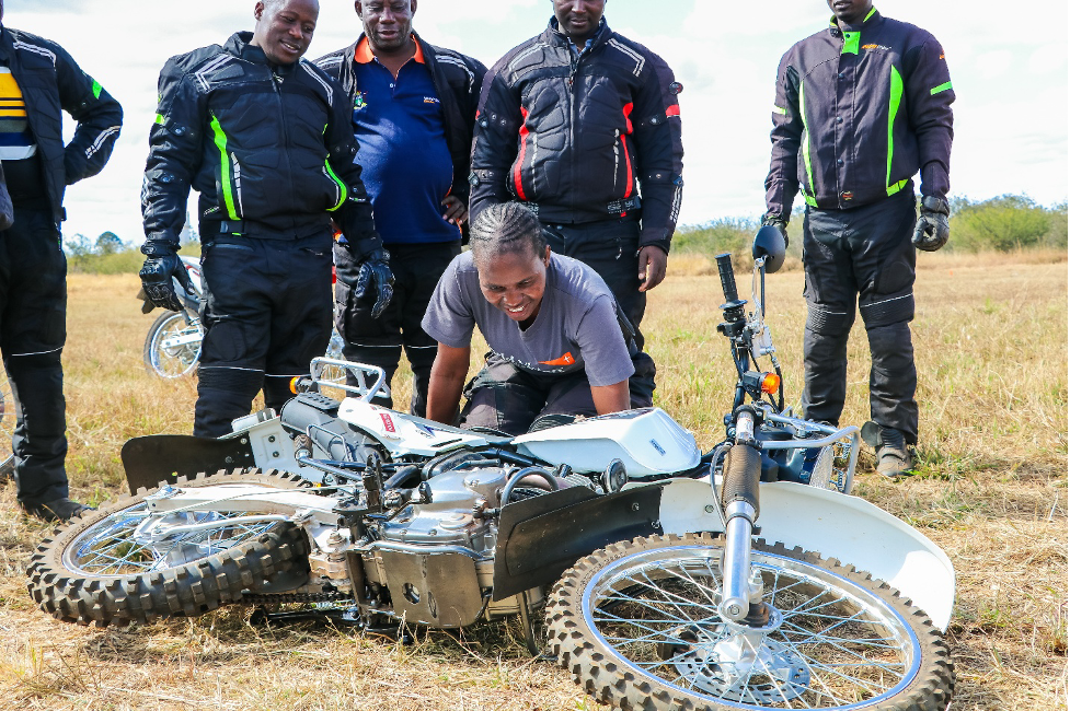 Rosemary demonstrating how to safely lift a motorcycle when one is involved in a crush.
