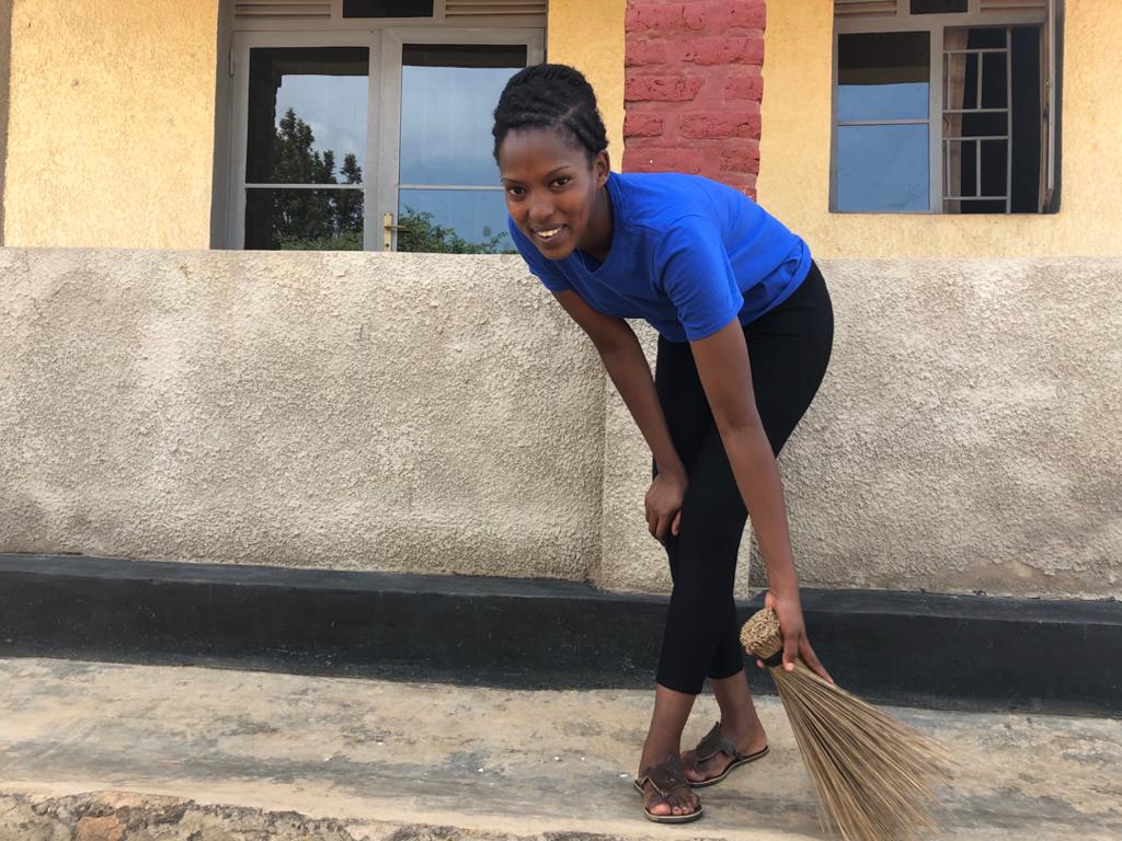 Rose sweeping the compound at her parents' home