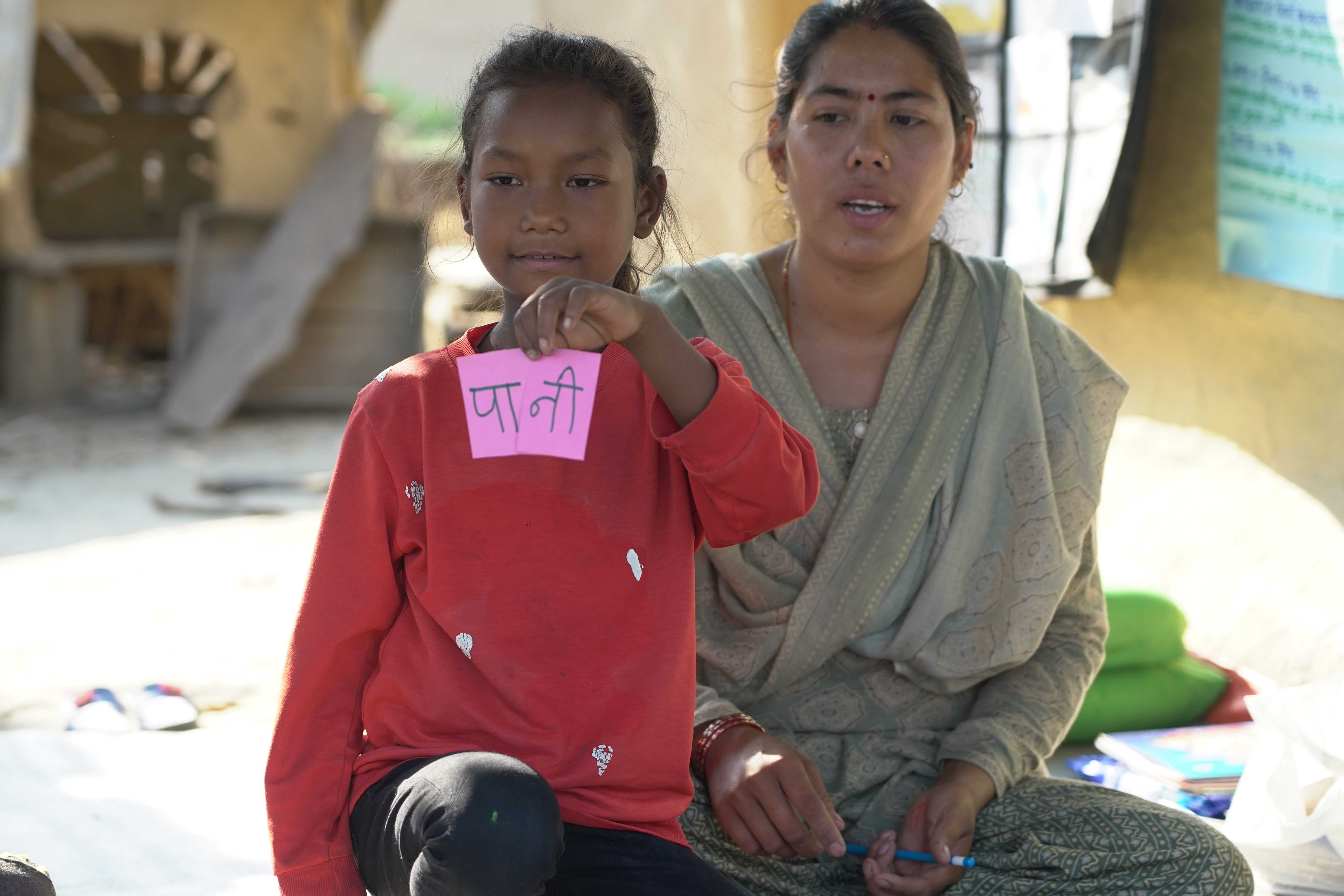 Swastika shows the letter she formed with Nepali alphabets