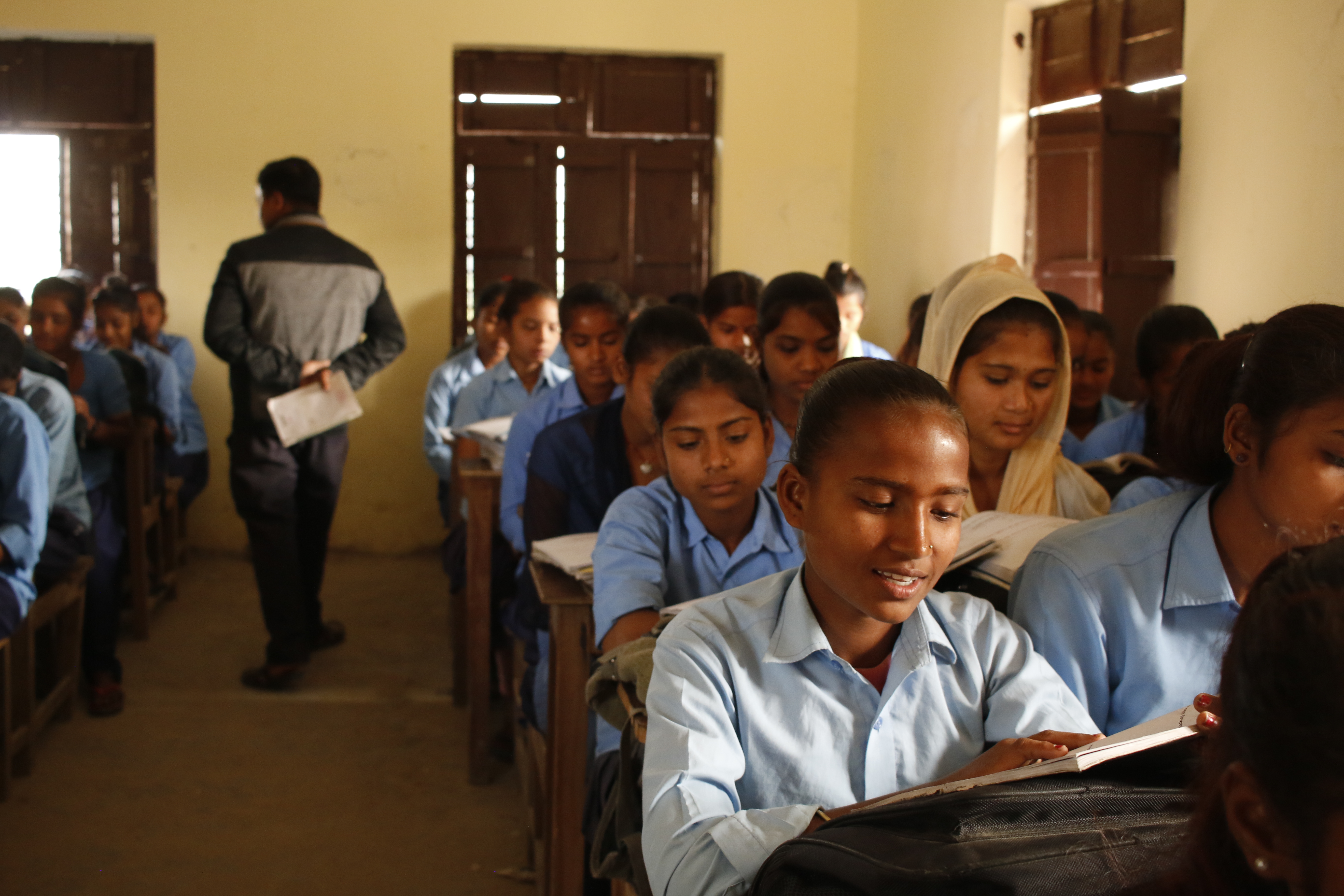 Saloni reading the book in her classroom together with her school friends