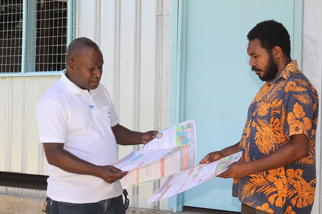 Wesley Tringin, the Project Coordinator handing Fact Sheets to Riwo SDA Primary School Head Teacher, Mr Joe Benjamin.