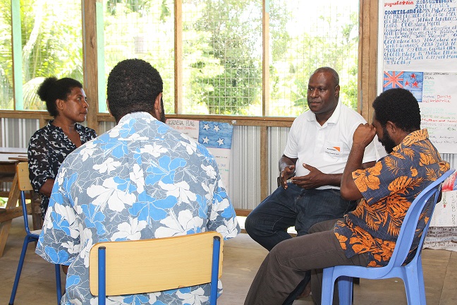 Wesley Tringin, having a discussion with teachers from Riwo SDA Primary School. The school is one of 10 in Madang Province where the Child Focus Disaster Risk Reduction Project is being implemented by World Vision.
