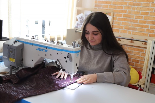 Teenager sewing purple cloth