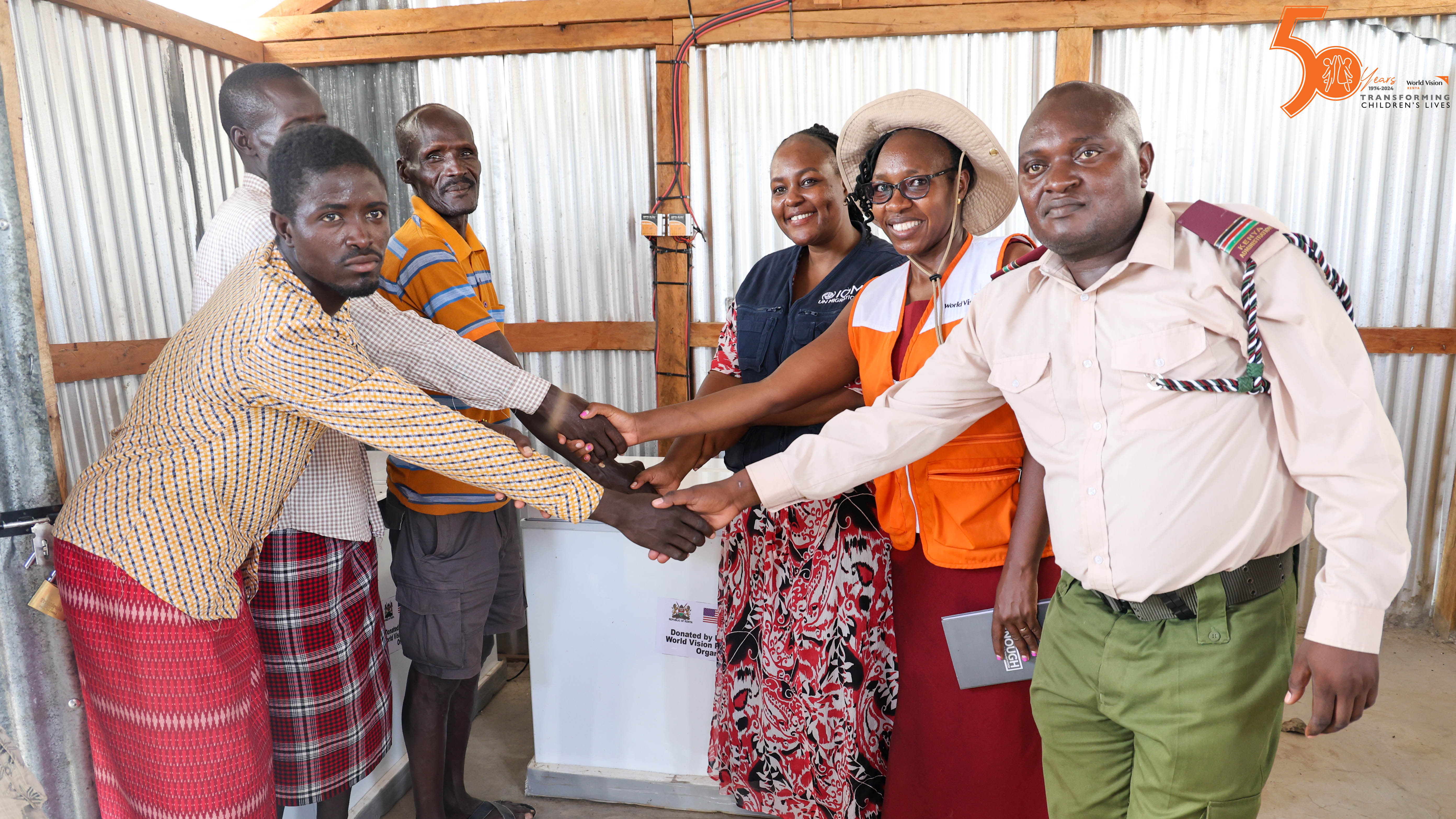 The official handover of the fish coolers to Nairen Abun, the Altoar Group Leader in Moite village group saving by Linda Kola, the National Resilience Officer-JTiP for the IOM together with Lilian Chebon, the Program Officer, World Vision Kenya and the Assistant County Commissioner, Marsabit County.