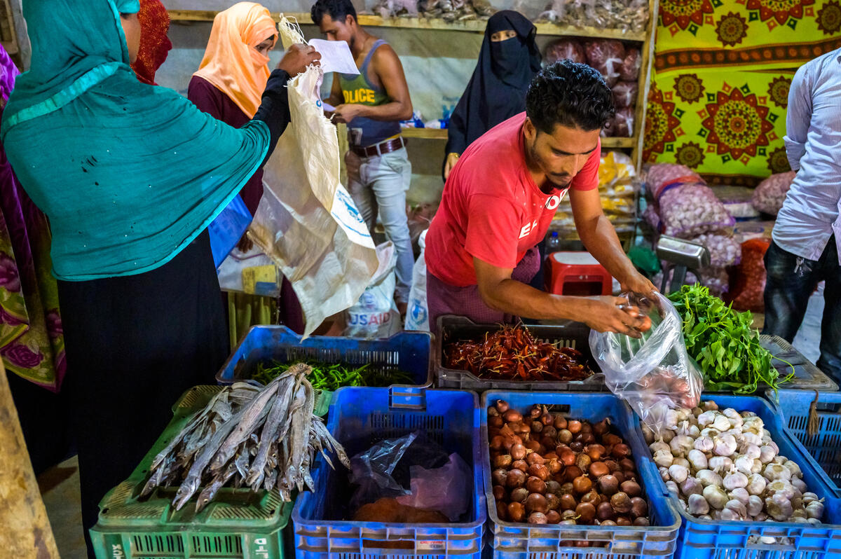 Rohingya refugees redeem food vouchers in a market in Bangladesh