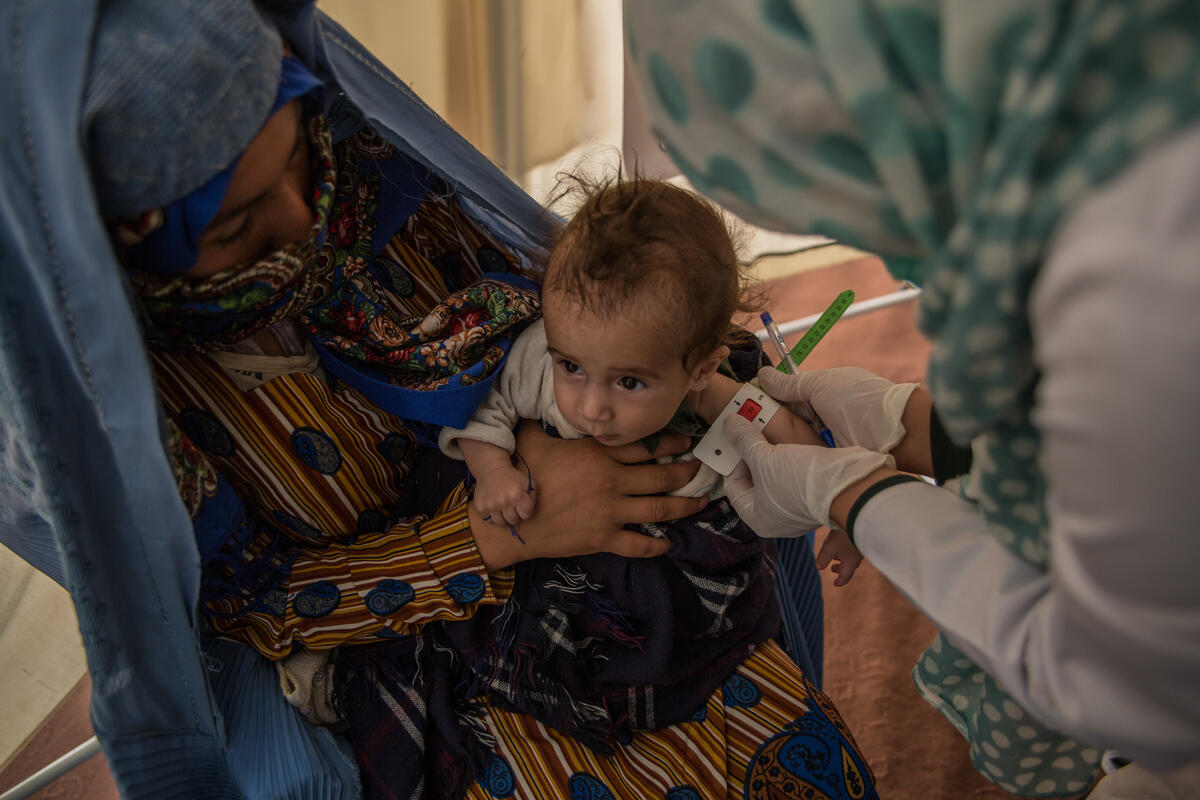 World Vision staff measure the arm of a child to see how malnourished they are.