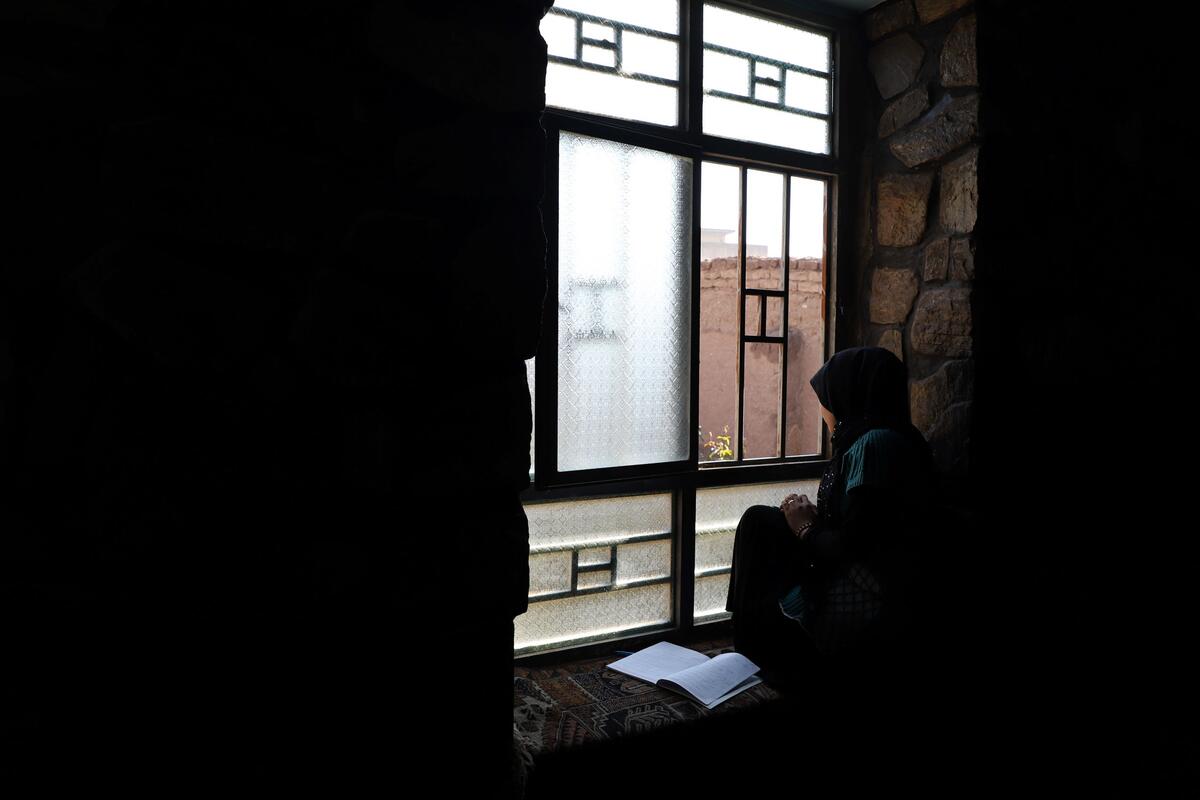Girl sits by the window in Afghanitsn