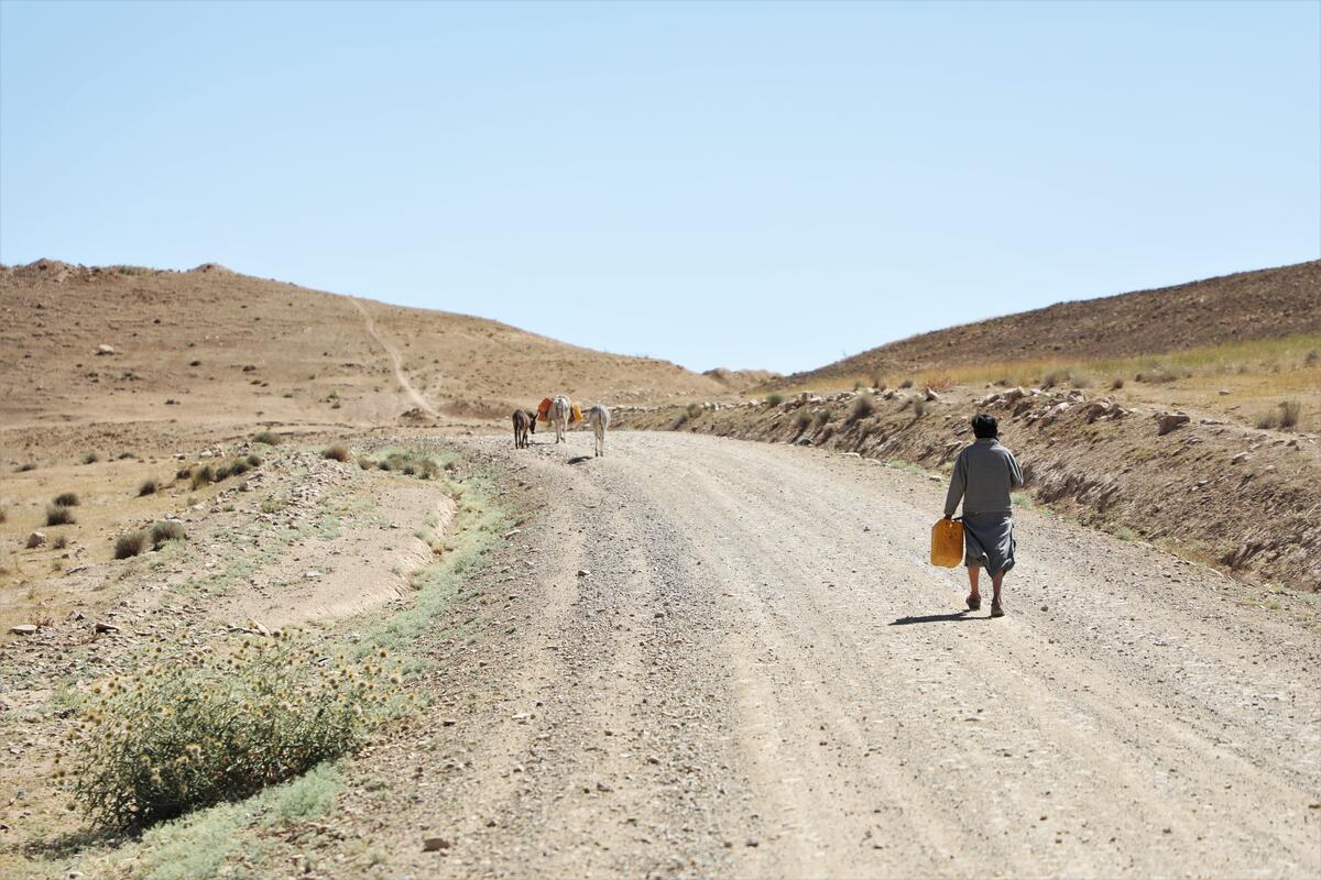 children take water from far water source outside a village in Afghanistan. 