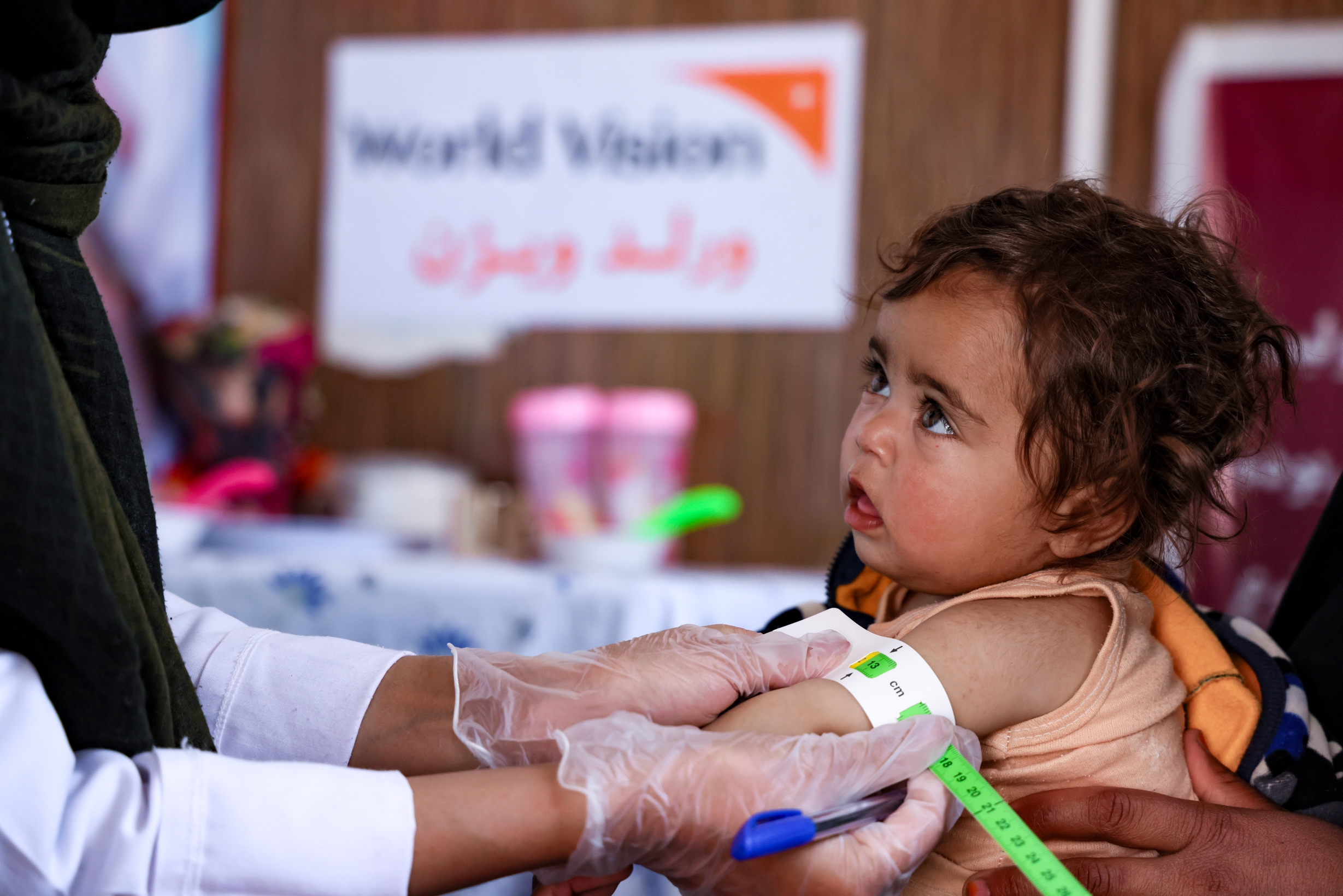 A doctor from World Vision clinic measures Parisa's height, which has reached 62 cm following nine weeks of nutritional services.