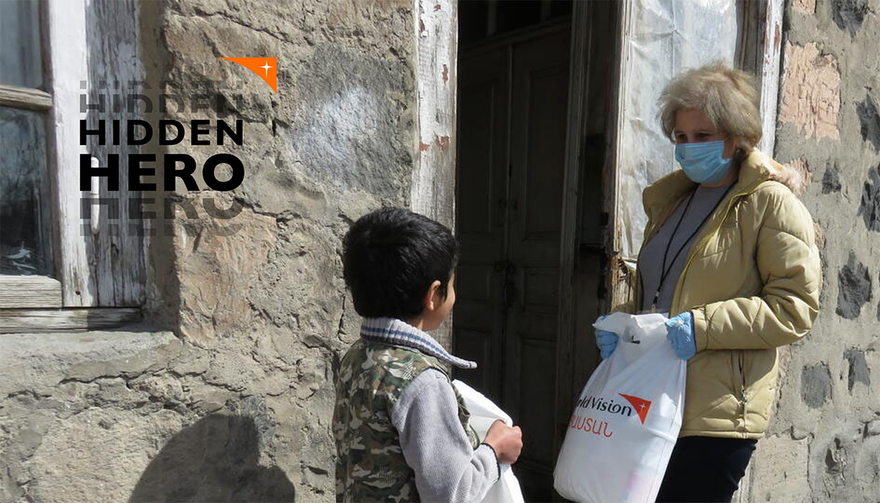 Hidden Hero World Vision staff hands supplies to child in eastern europe
