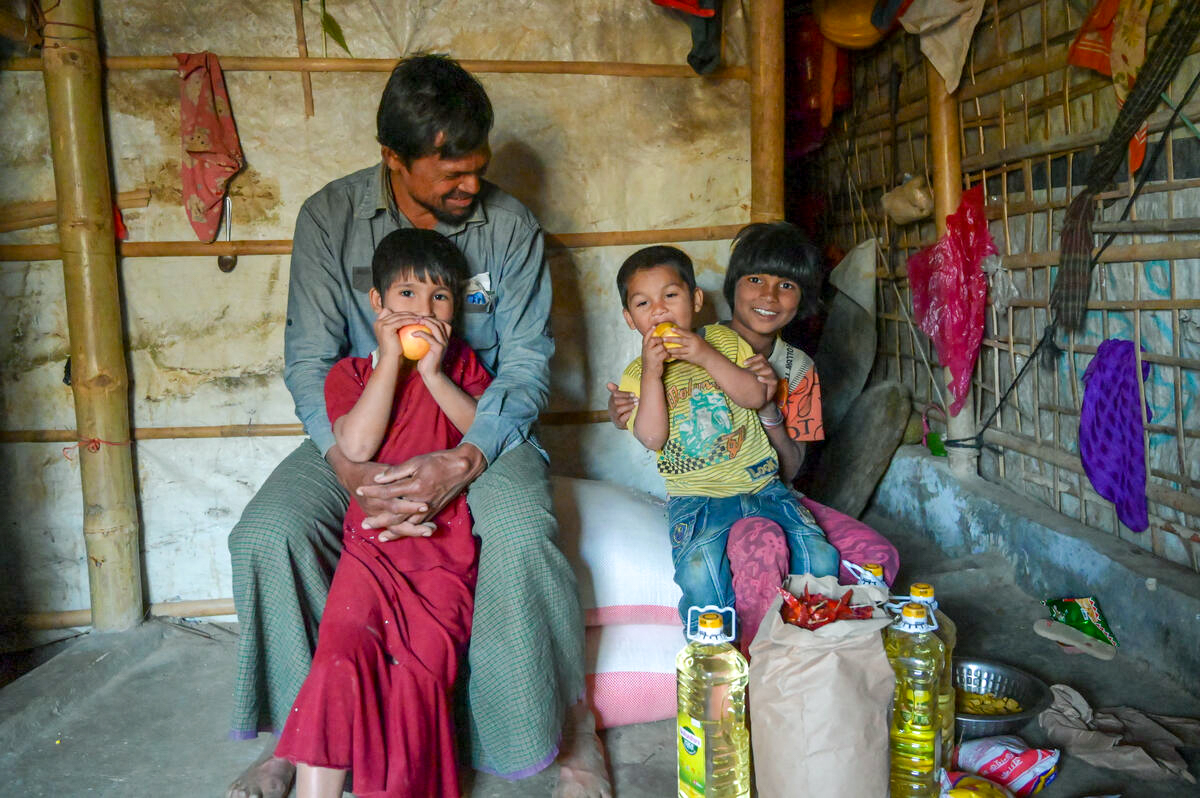 Najir’s children enjoy the apples he bought as part of monthly food ration from the World Food Programme e-voucher store, which is run with support from World Vision. Photo: Himaloy Joseph Mree, World Vision