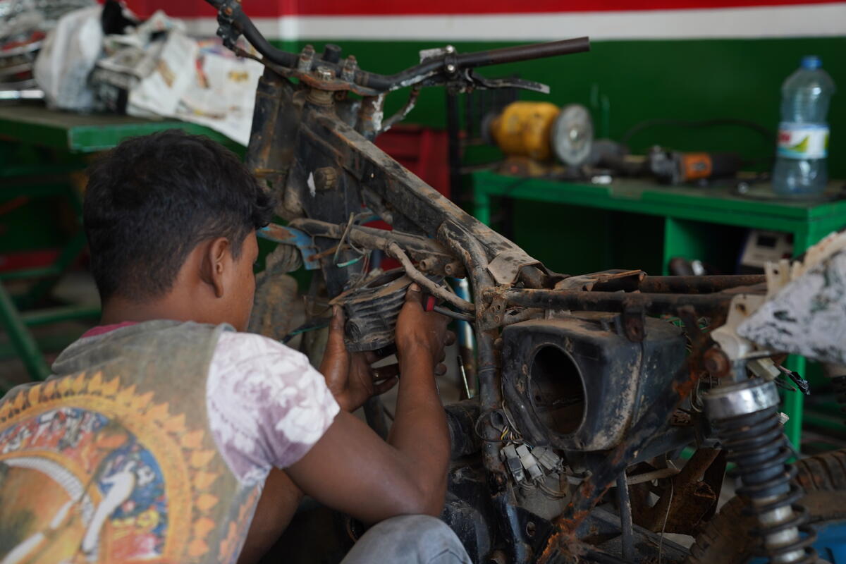 boy fixing a motorcycle 