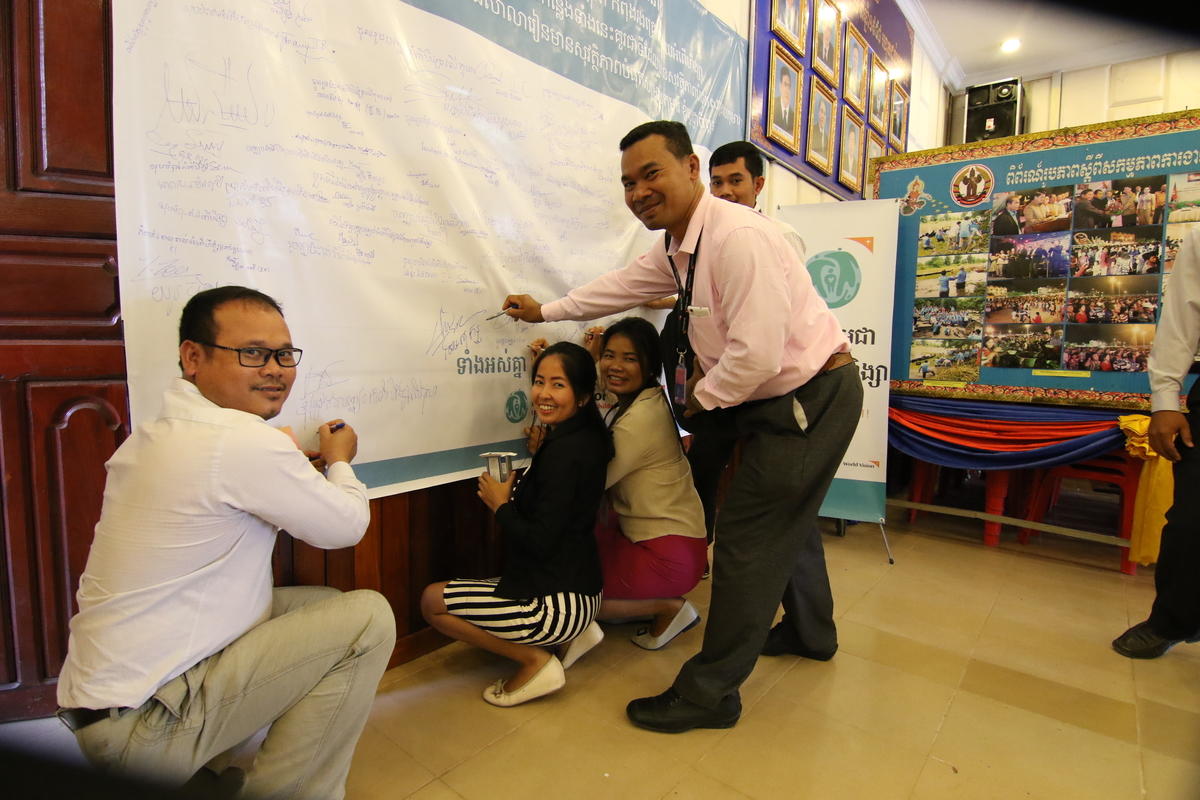 People sign a giant commitment document