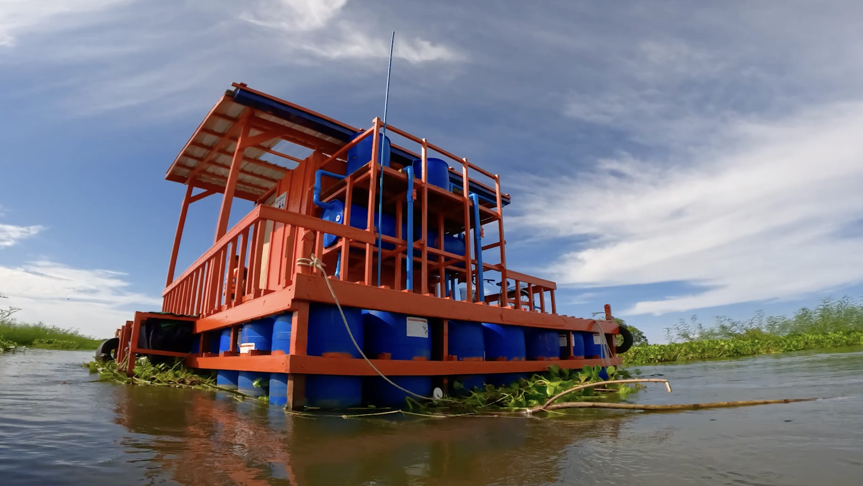 A blue and orange floating sanitation solution sits in a lake in Cambodia..