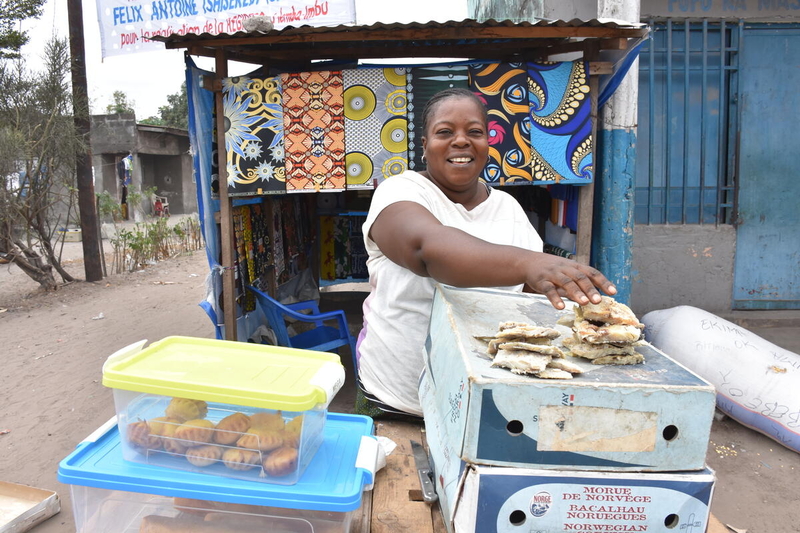 Mamie, a Congolese entrepreneur, in front of her food stall 