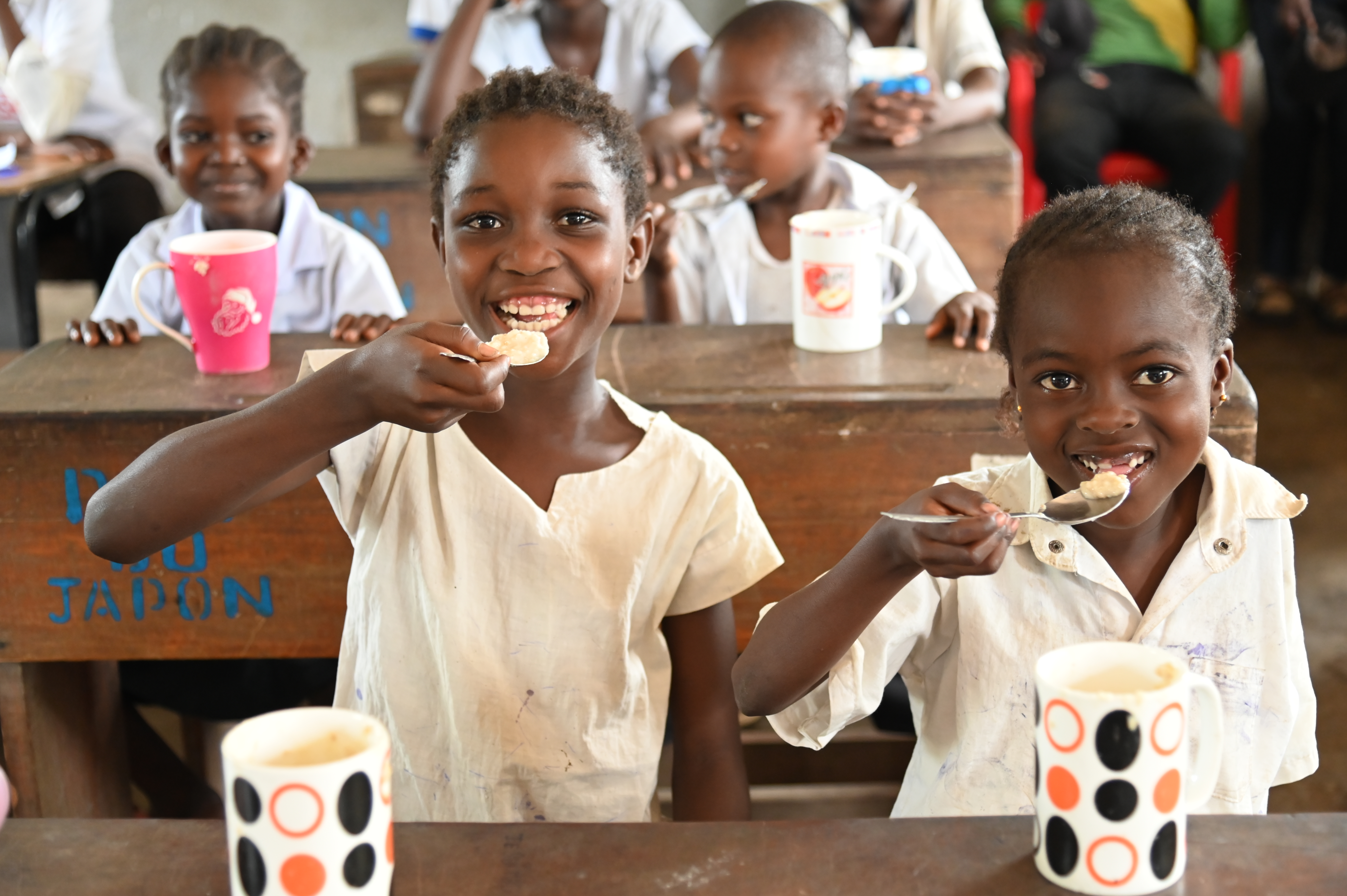 Mireille, 10 years old, enjoys her porridge with great appetite, her face radiating joy as she enjoy each spoonful. Didier Nagifi / DRC 2025