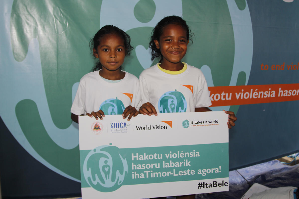 Two girls hold a banner