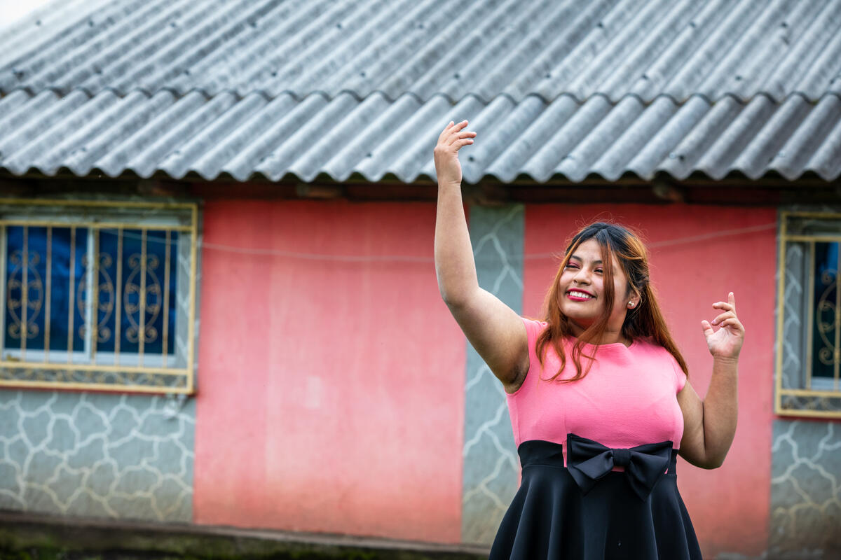 girl stands outside a house dancing