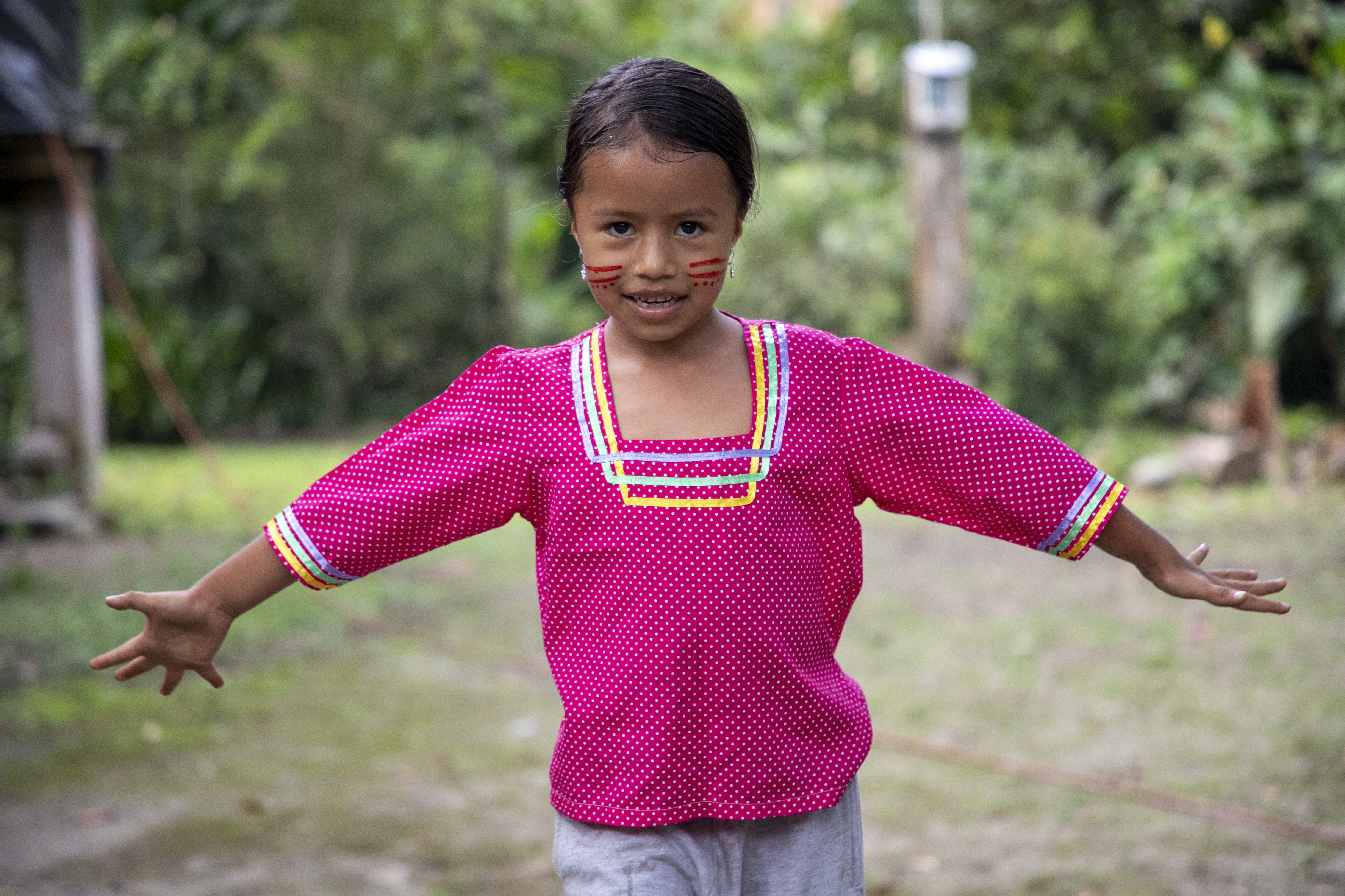 A little girl smiles warmly at the camera in the heart of the Ecuadorian Amazon.