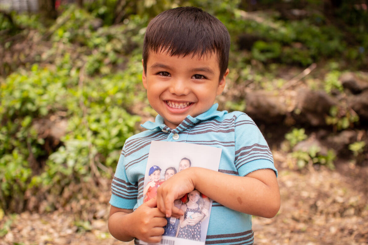 child holds image of their sponsor