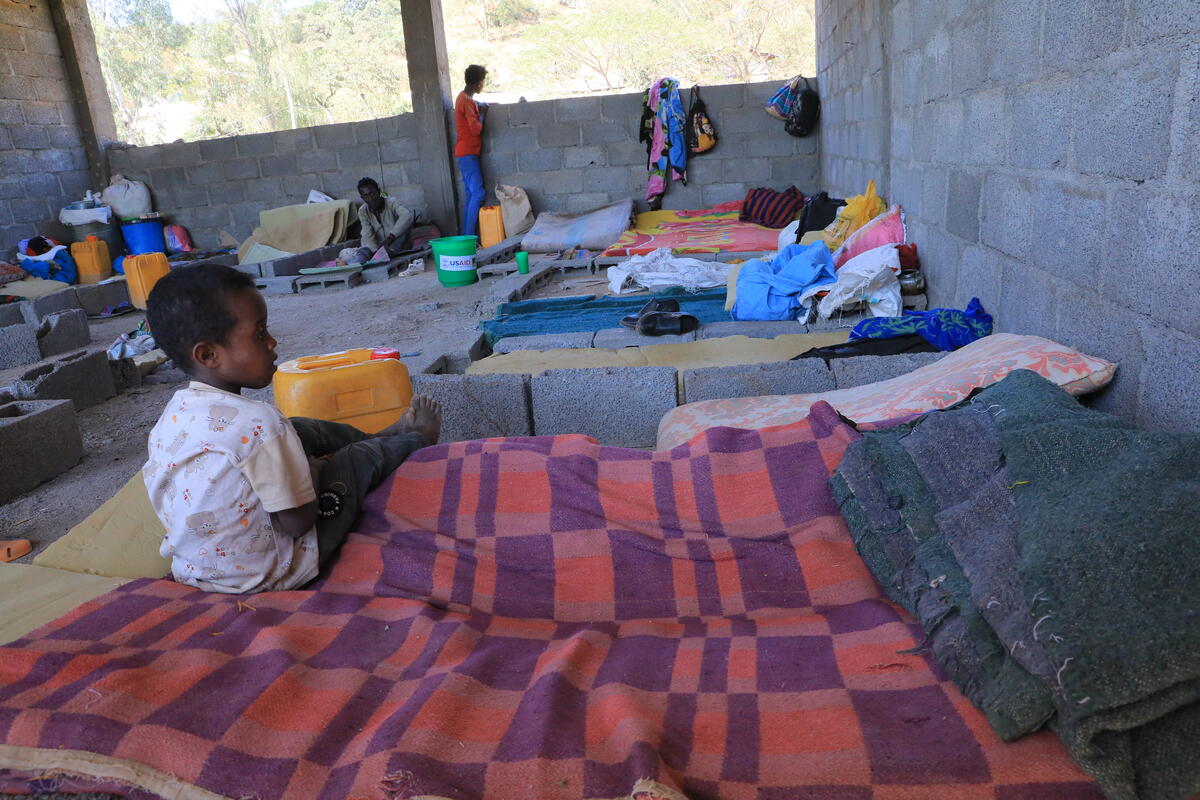 Child sits on bed in camp for displaced people in Tigray Ethiopia