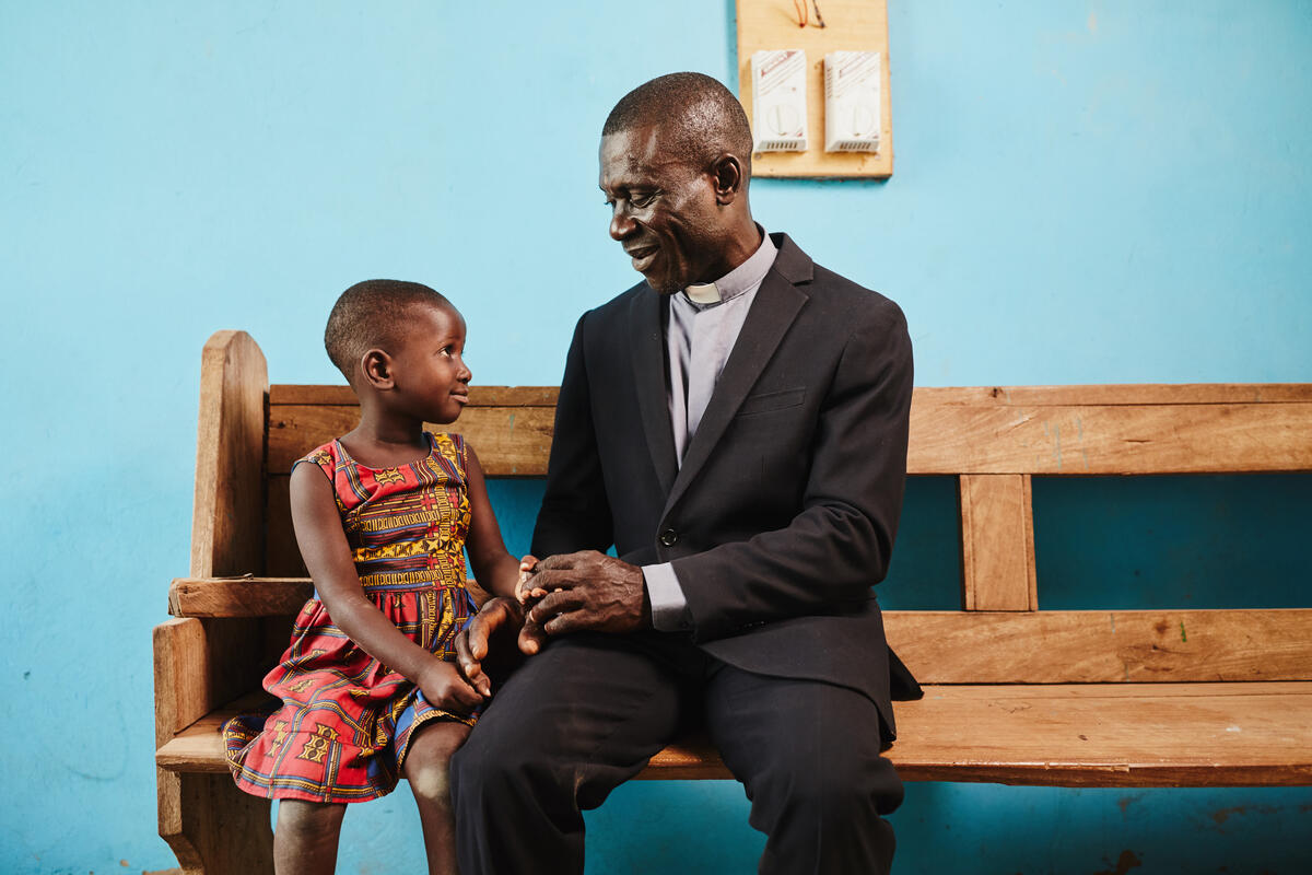 Priest in Ghana speaks with young girl