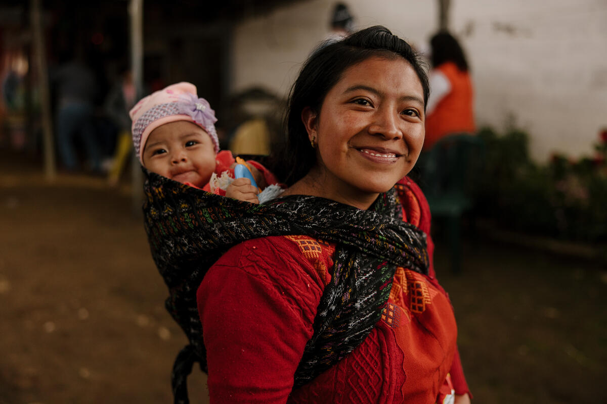 a mother carrying her child on her back