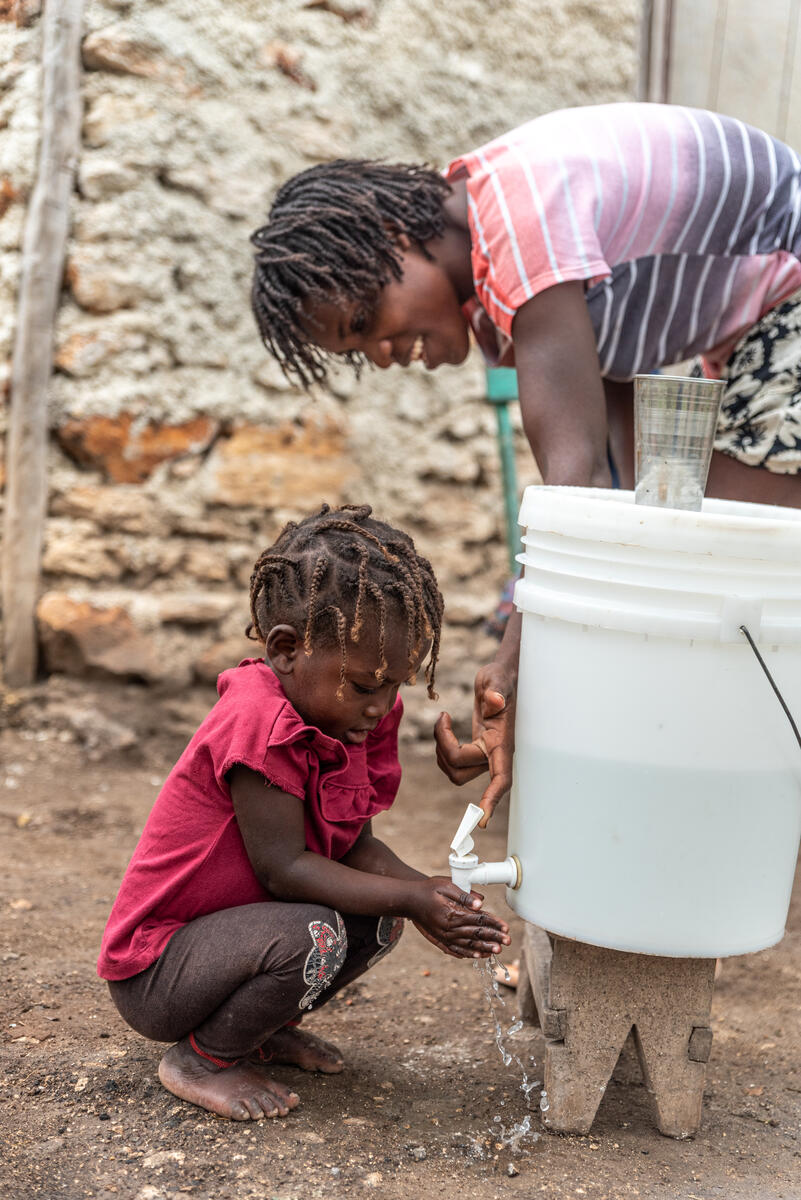 Young sponsored child Schamaelle in Haiti washes her hands at home.