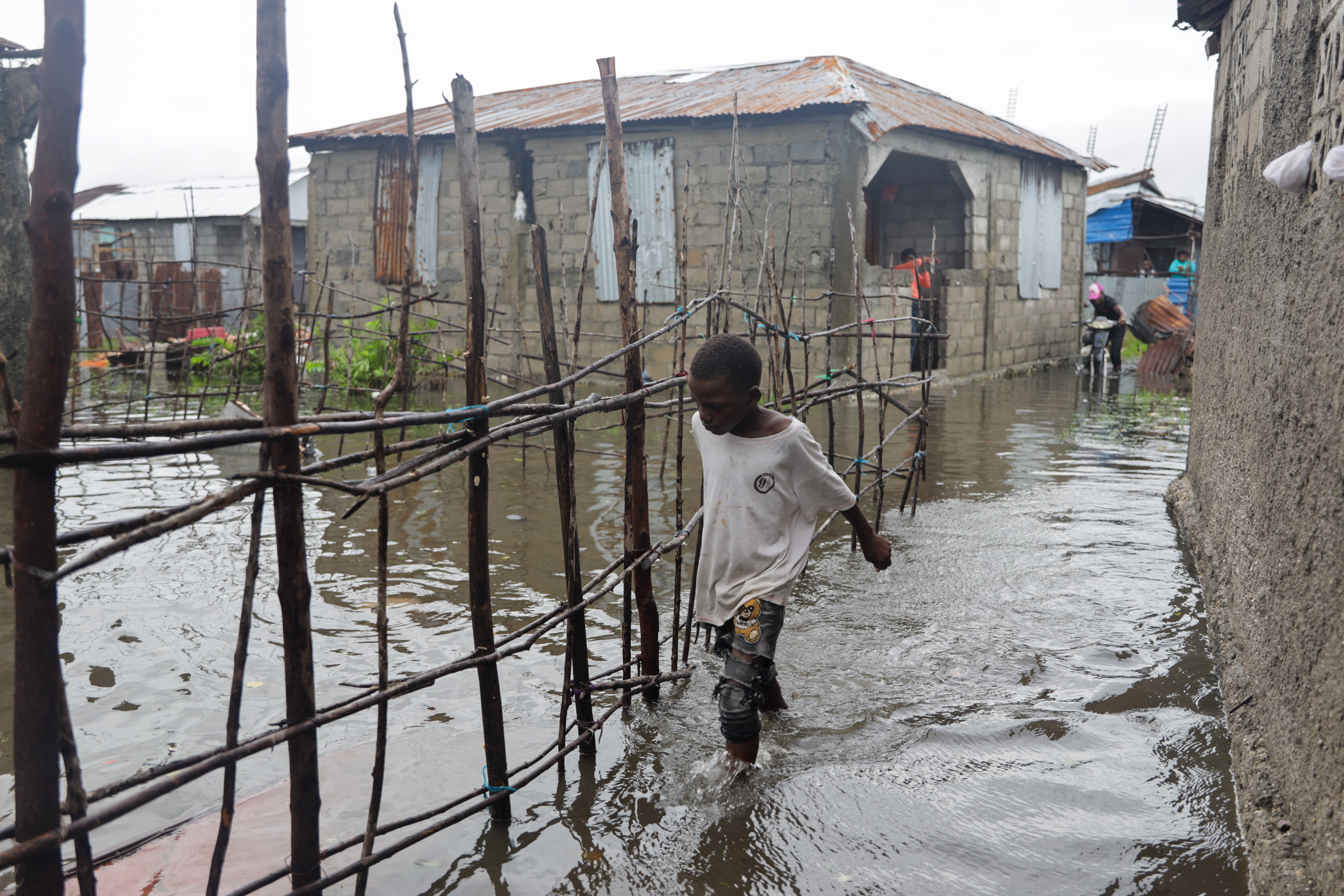 A child moves carefully through the waterlogged pathways of La Savane, Haiti, where rising water has flooded homes Haiti / 2025.