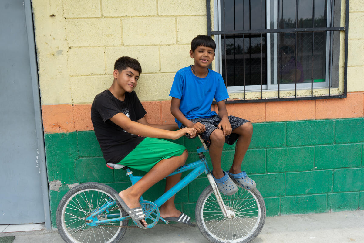 David and his friend sitting on a bicycle
