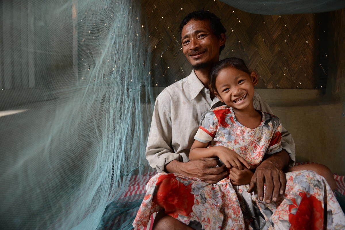 Ruthi and her father in India show their mosquito net.