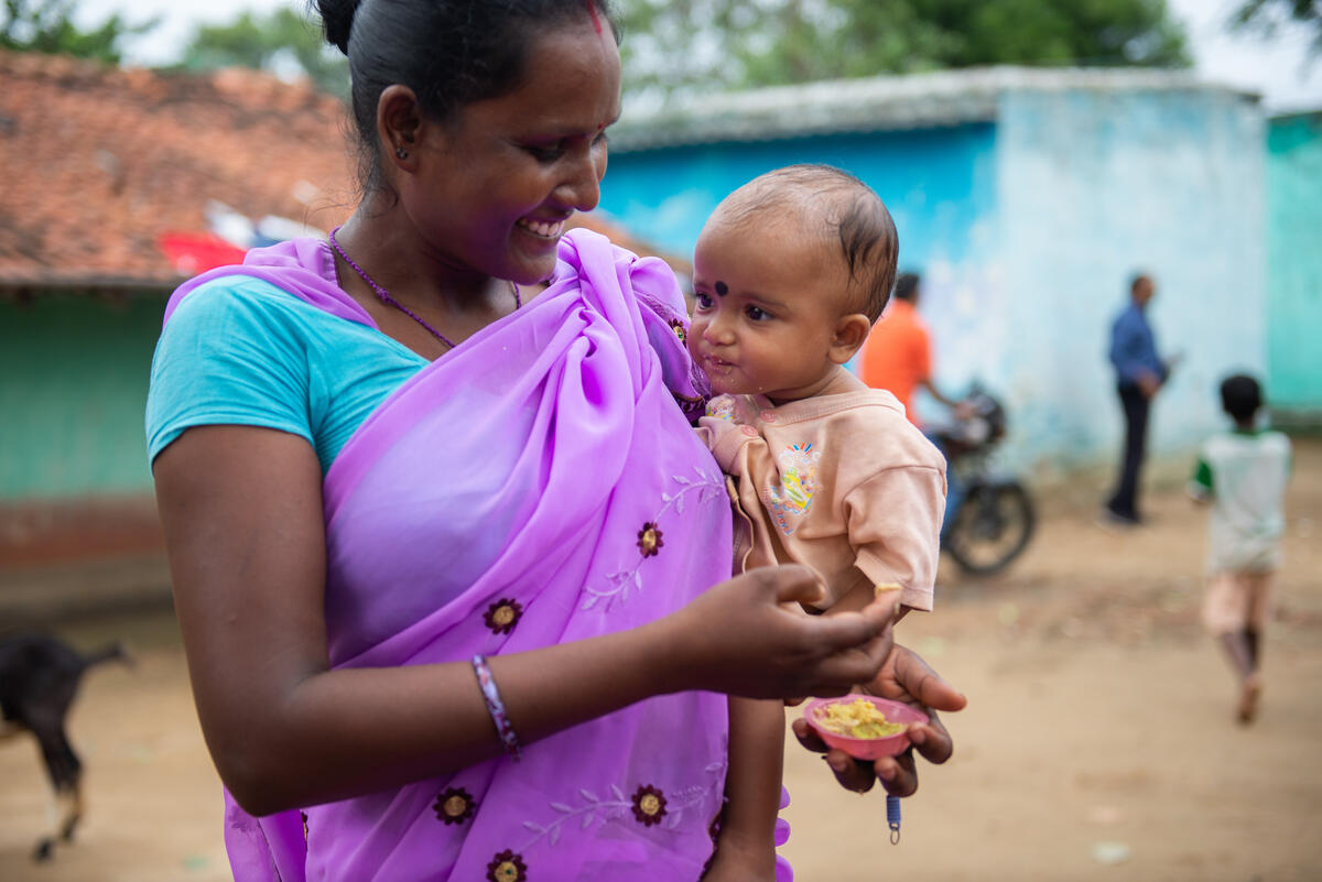 A happy mother and baby at the World Vision India cooking demonstration.