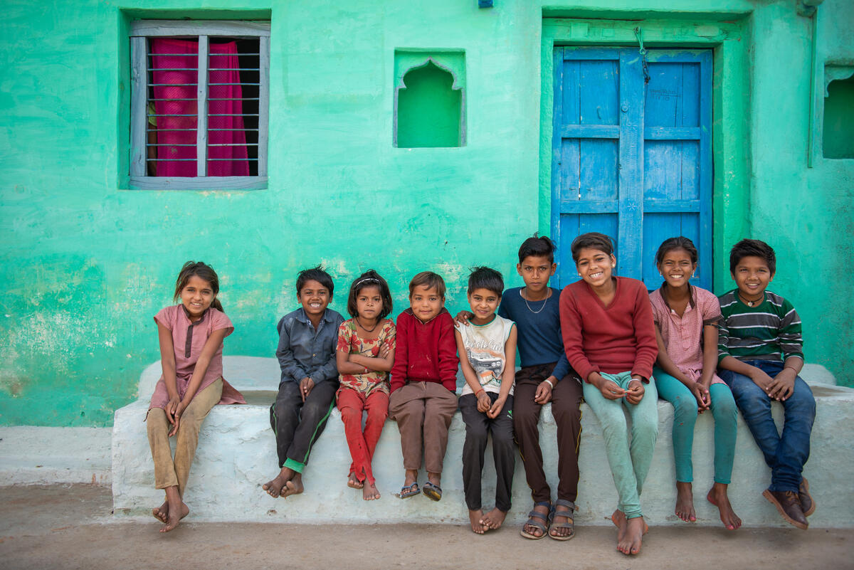 People through Hemant's village gather outside his barbershop.