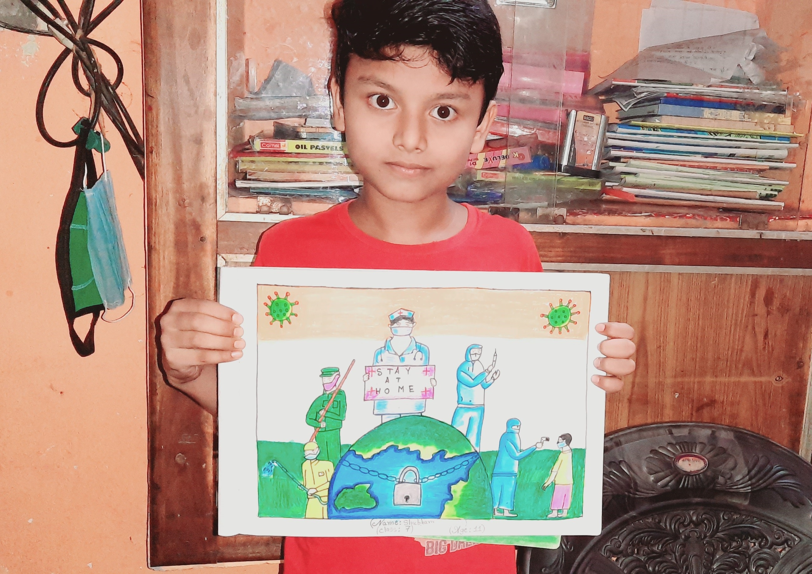 A child shows his drawing of the impact of COVID