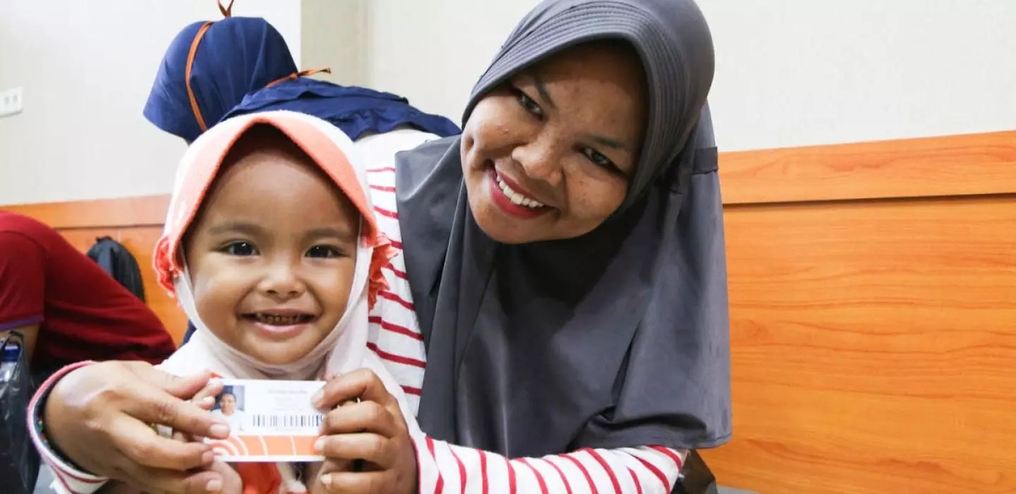 A mother and child in indonesia with a digital cash card