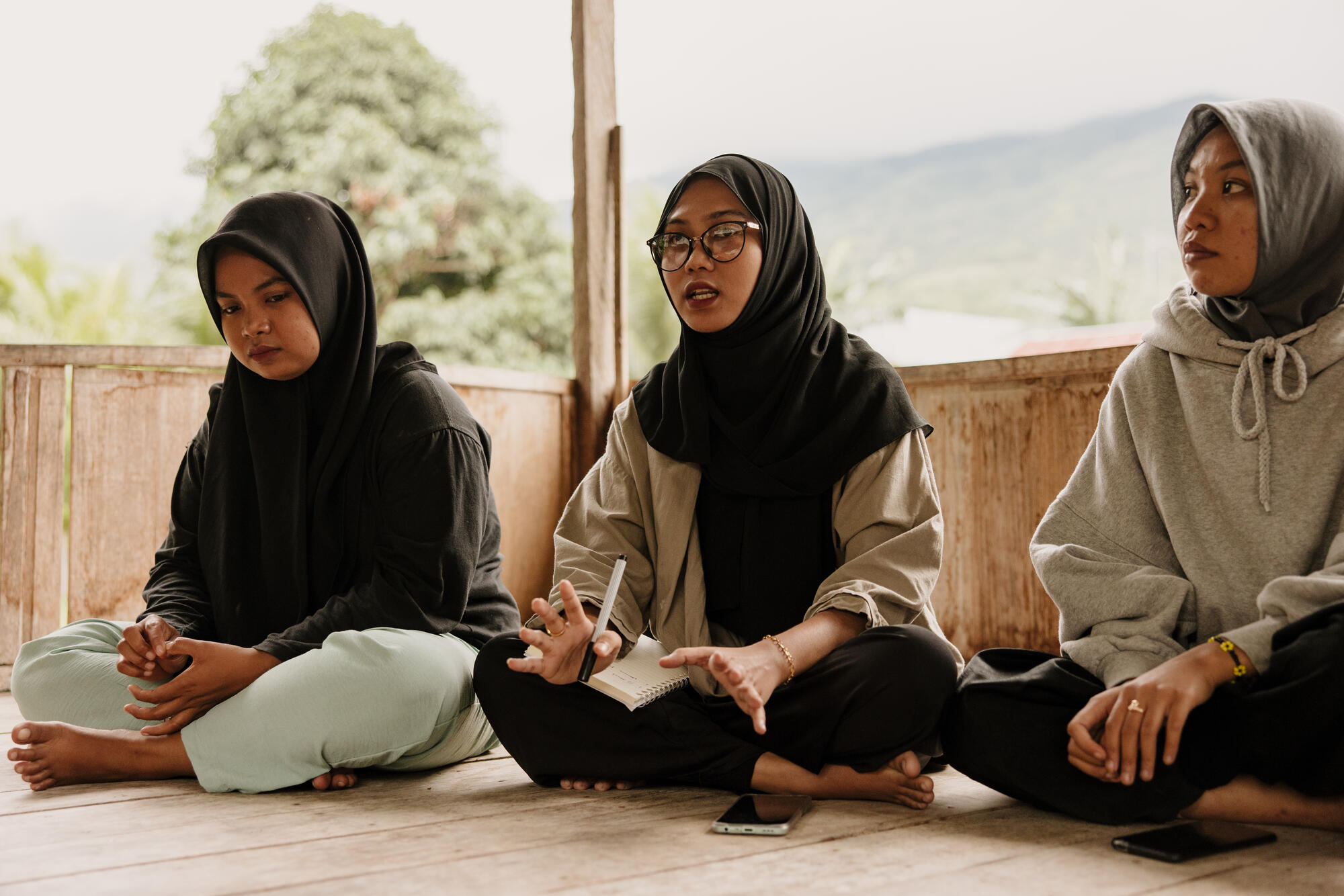 Three girls sit on the floor during a peacebuilding session in Indonesia