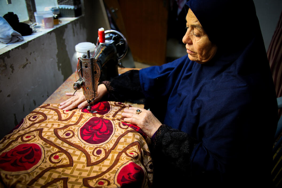 Fatouma tailoring in her home