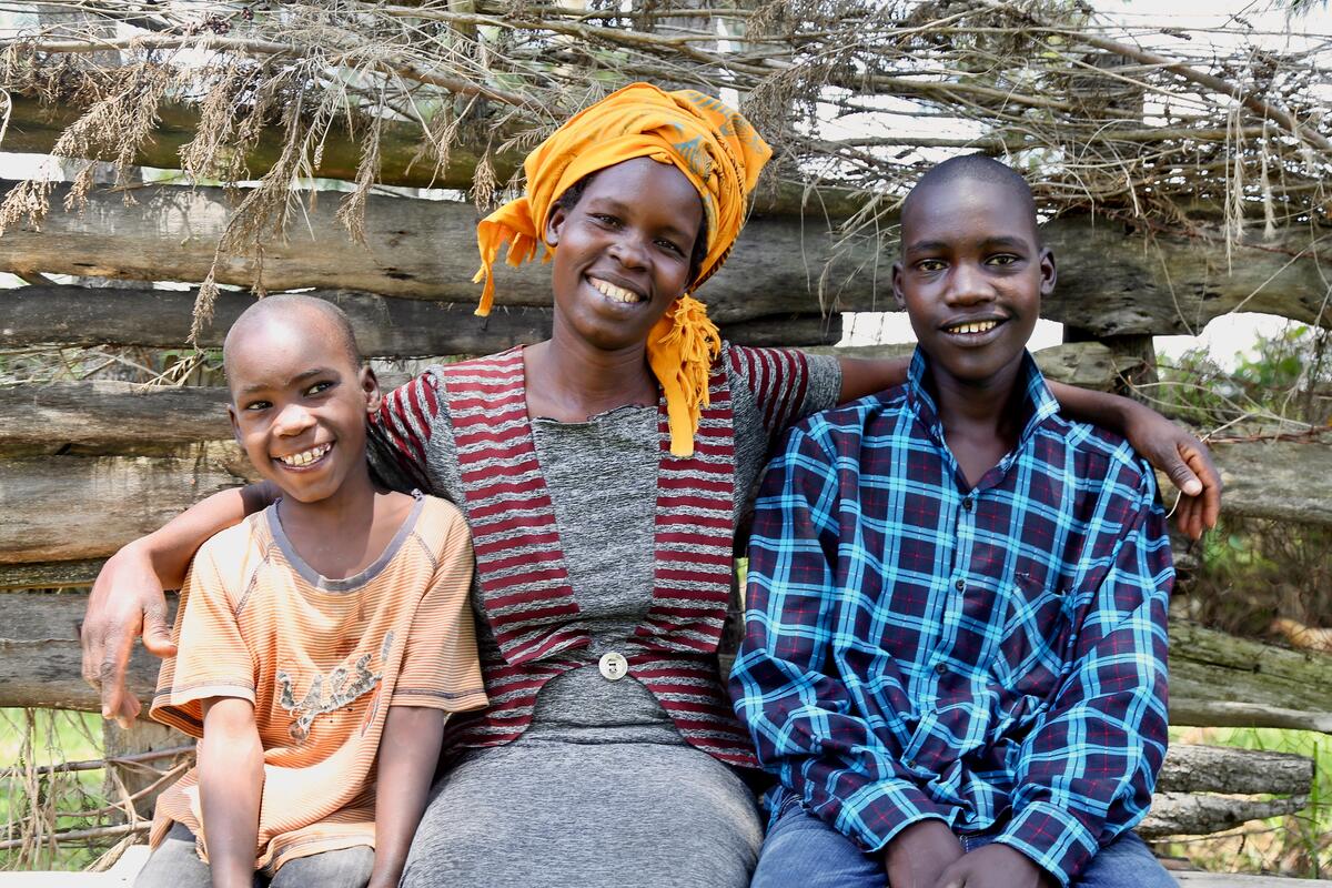 Mother in Kenya sits with her arms around her boys.