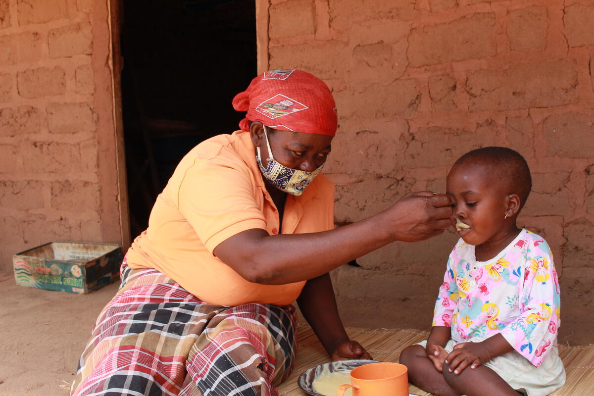 Augusta feeds her granddaughter Marlene porridge made with CSB.